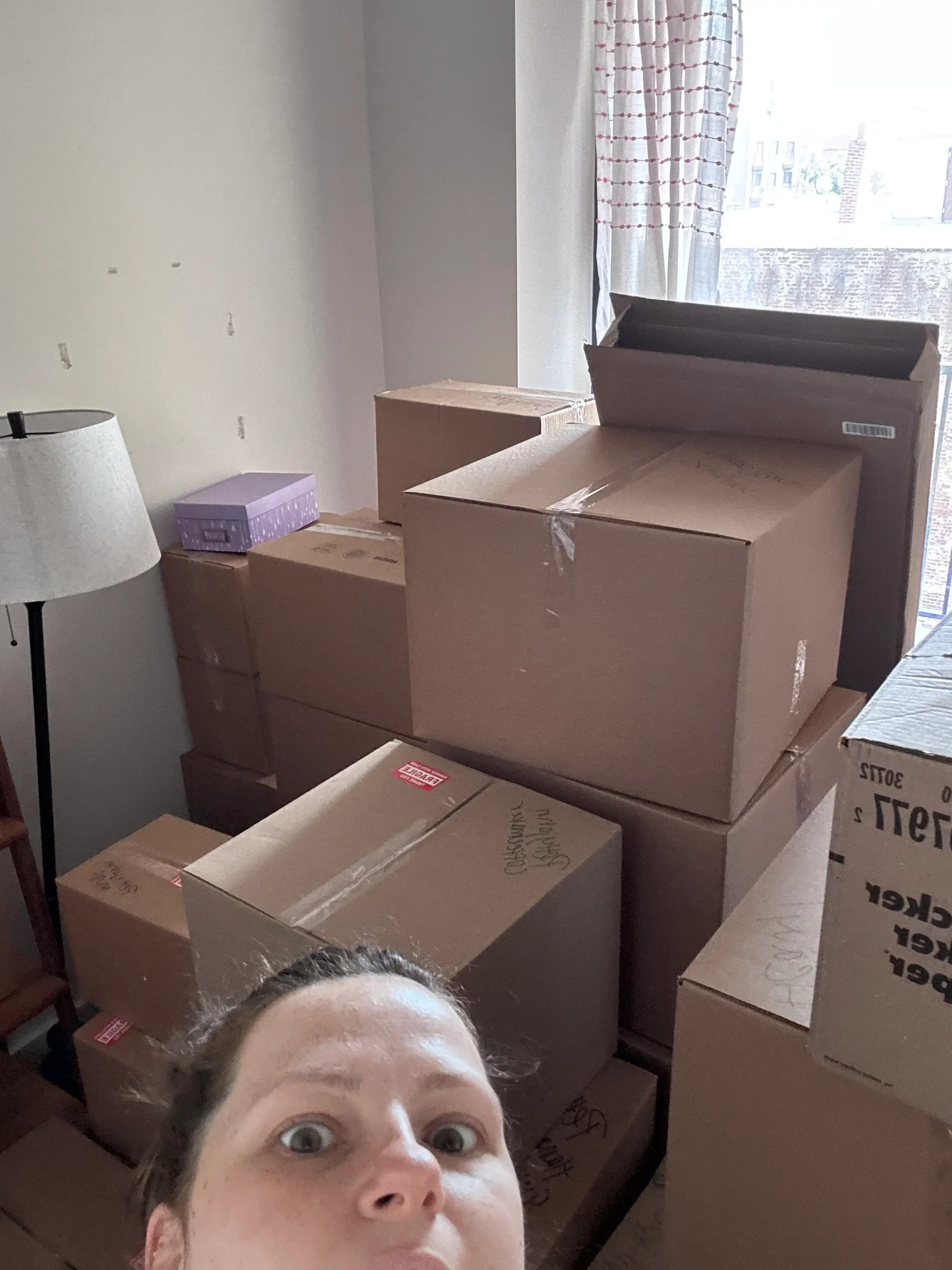 A selfie of a woman with boxes behind her.
