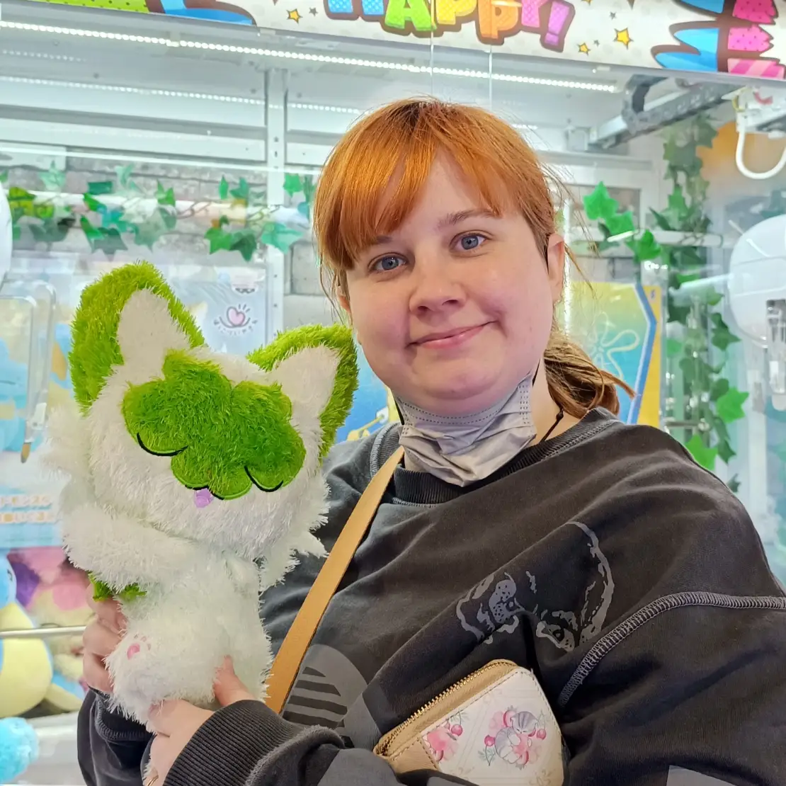 Woman smiling with plushie in hand