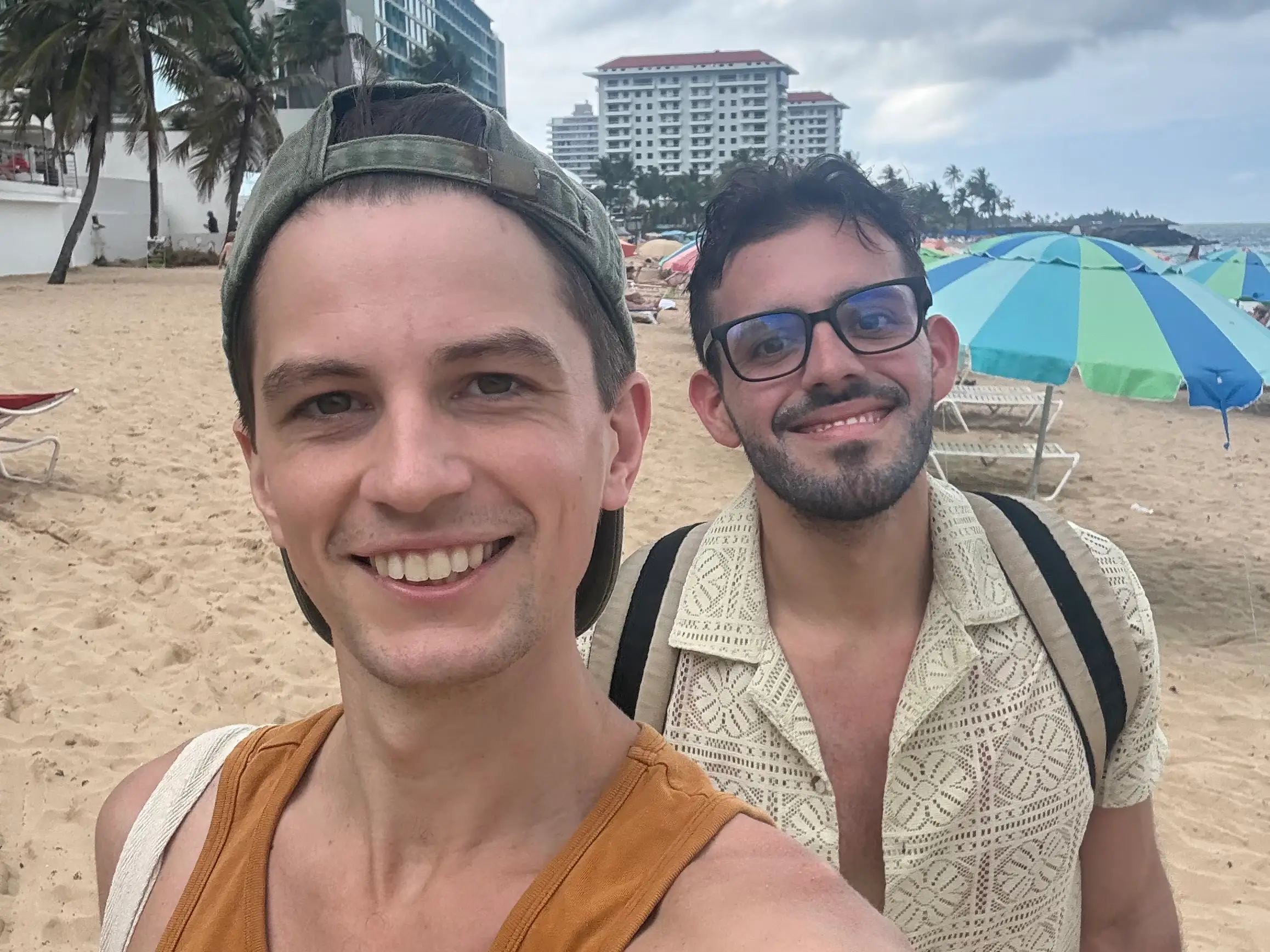 Two men smiling together on beach