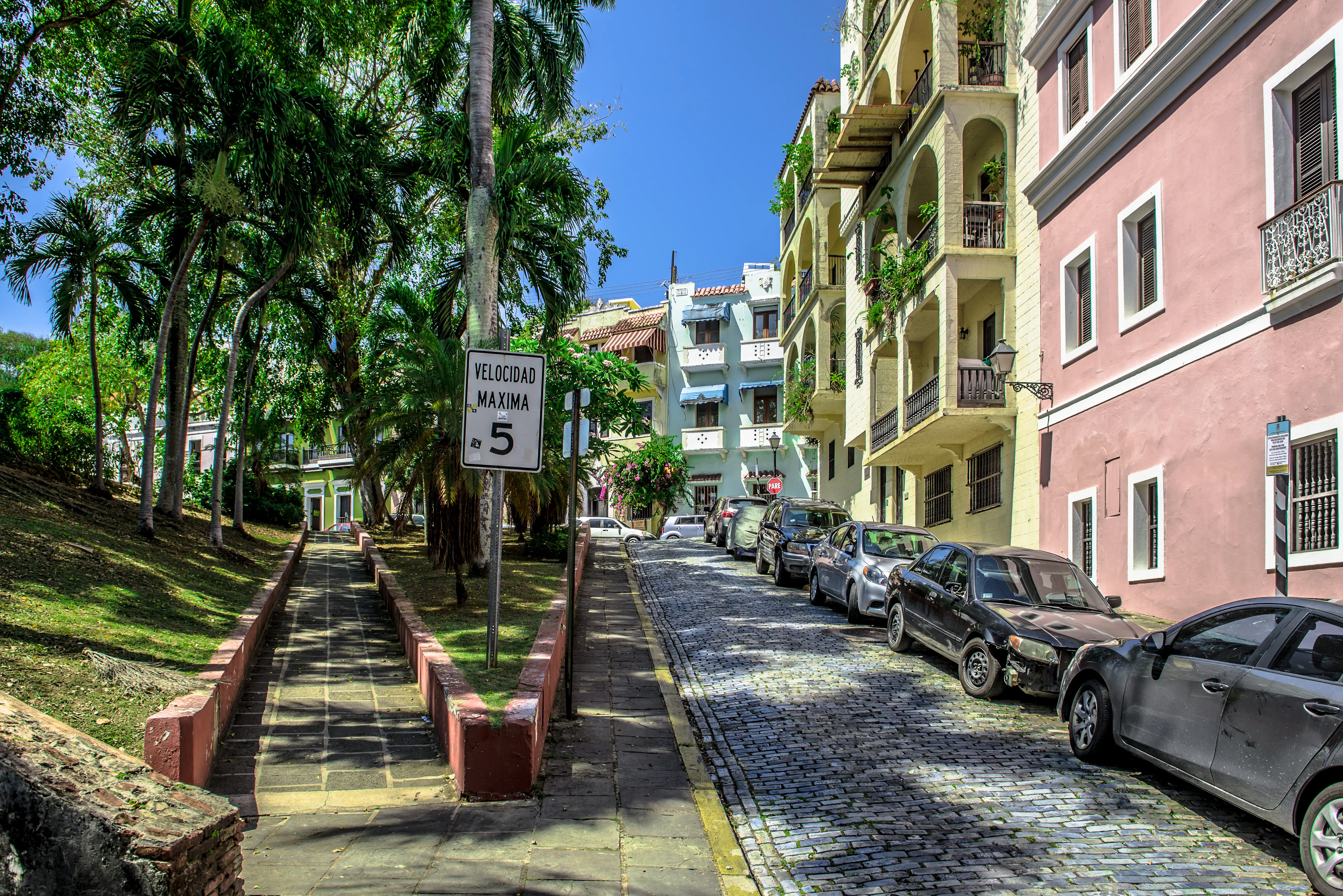 cobblestone street lined with parked cars in old san juan