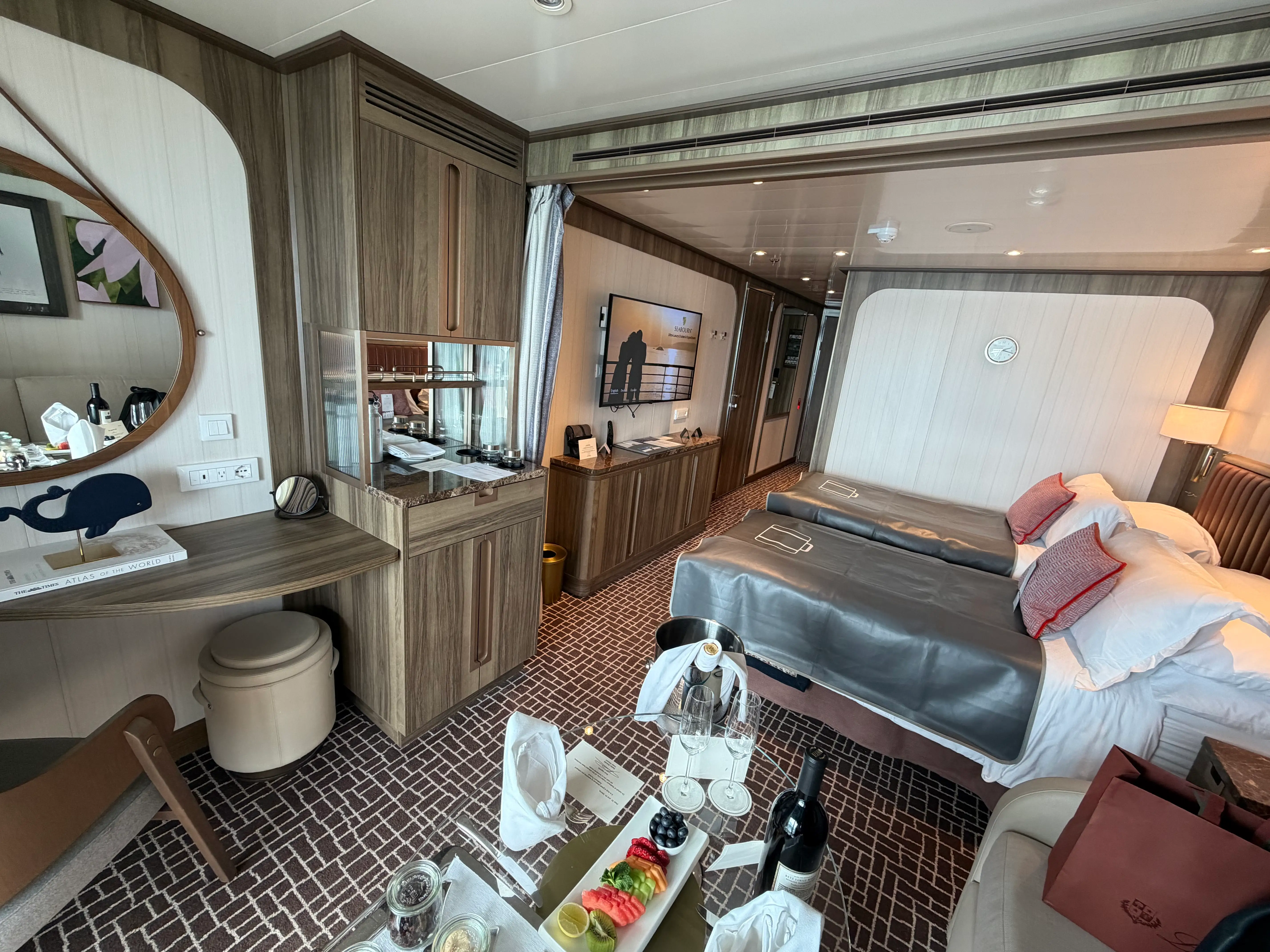 View inside Seabourn cabin with vanity area, mini fridge, beds