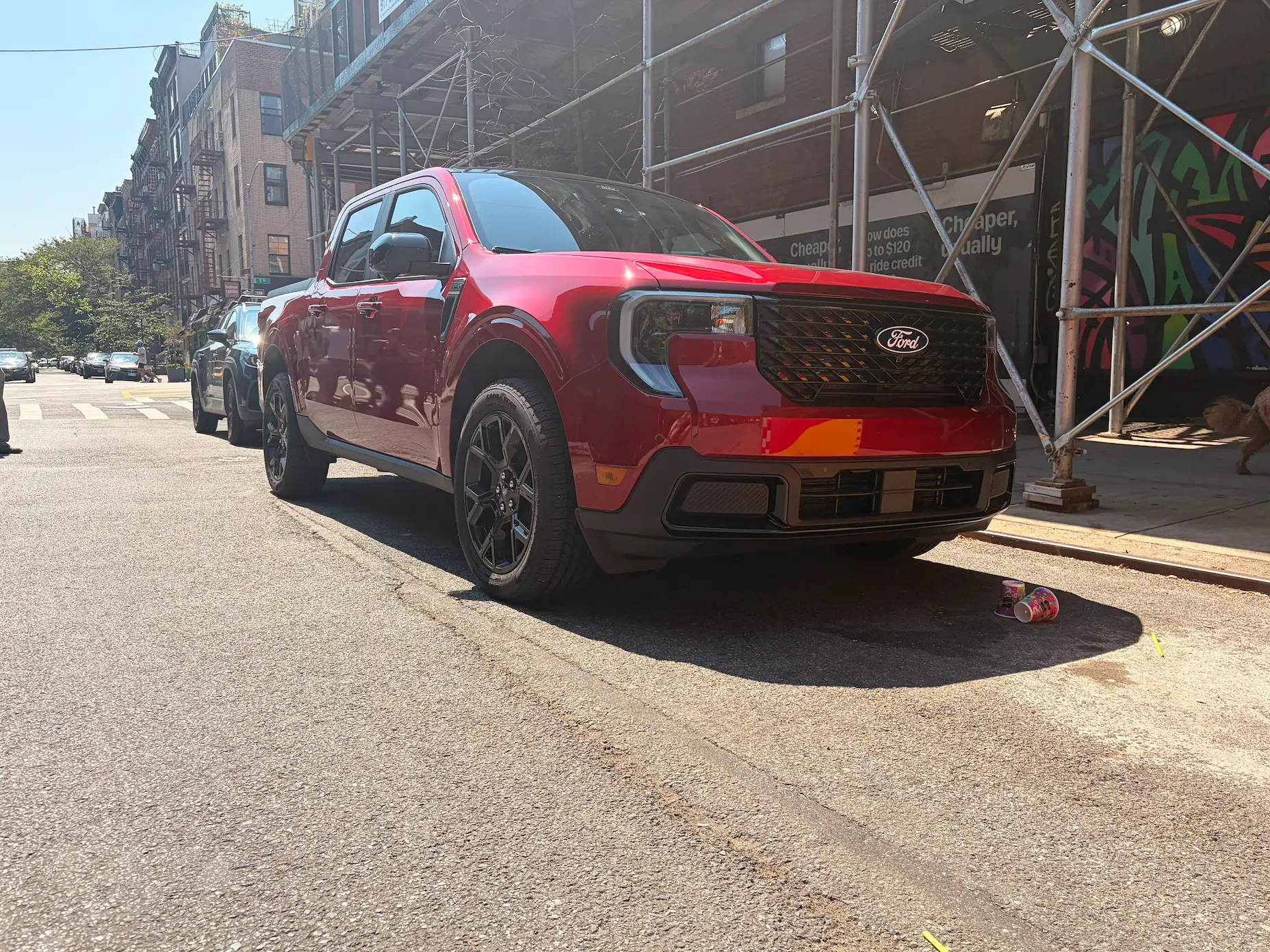 A red Ford Maverick Hybrid is parked on a New York City street.