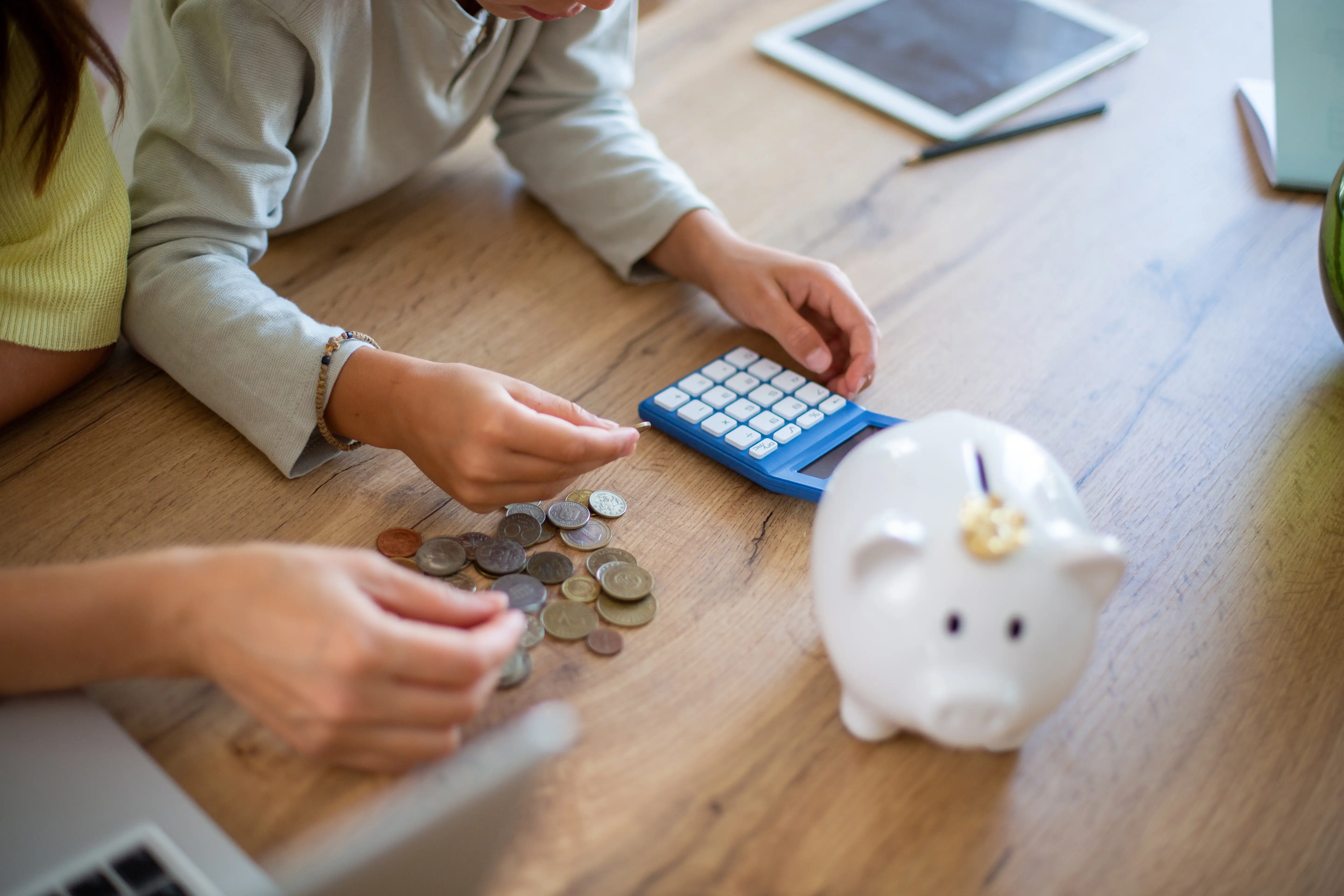 A child puts money into a piggy bank.