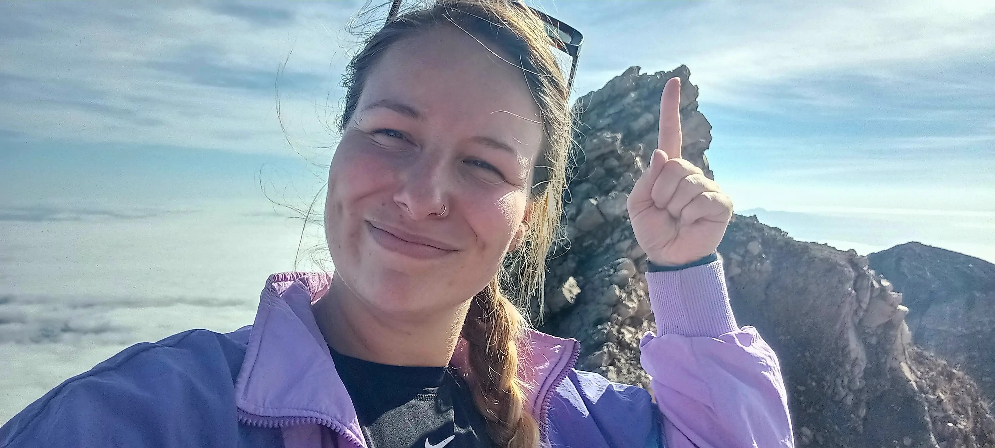 The author points to a rocky cliff.