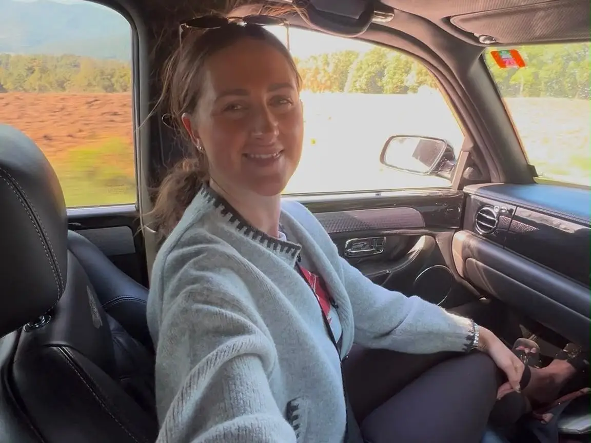 Abbie Manning is in the passenger seat of a Bentley car.