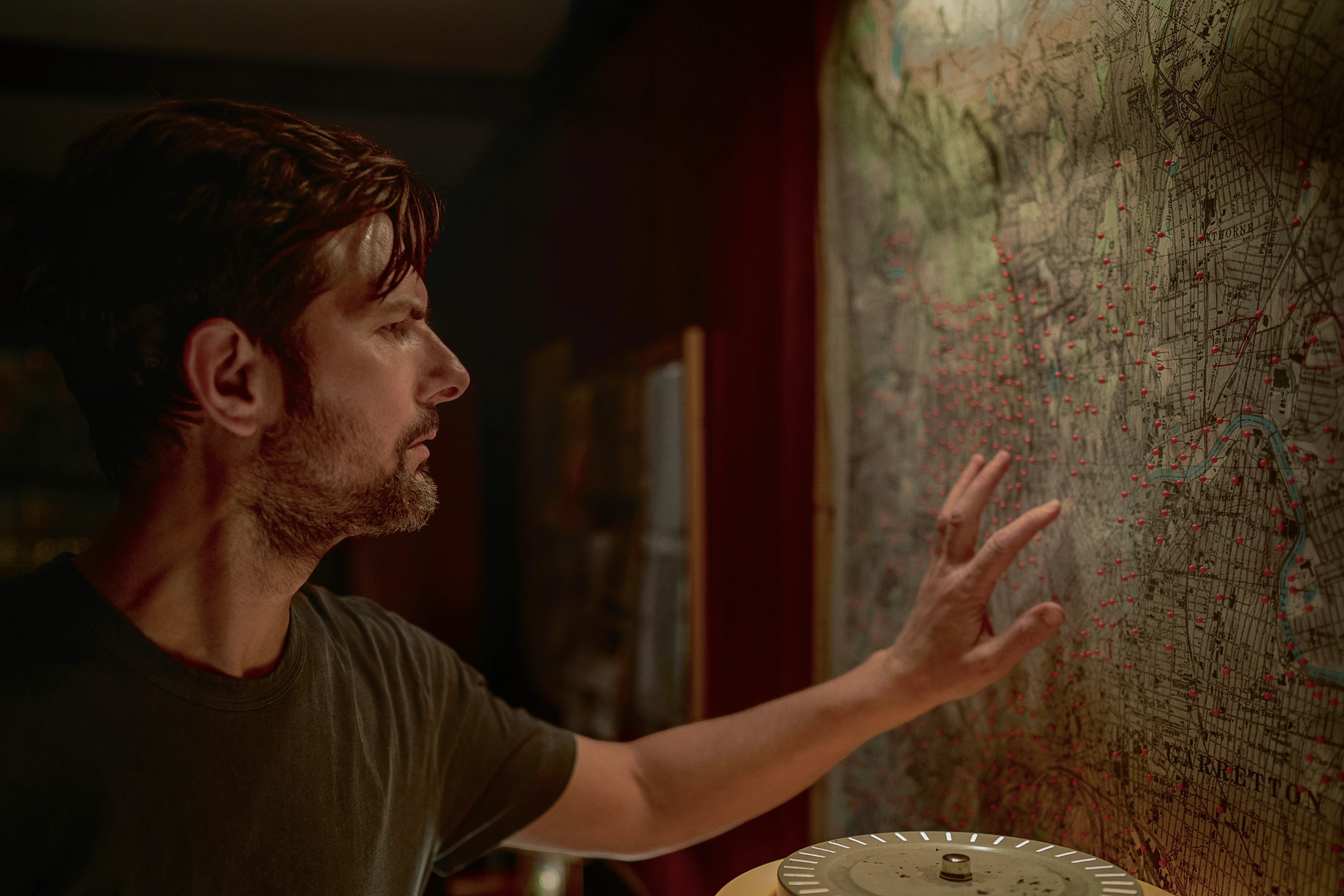 Adam Scott putting his hand on a map