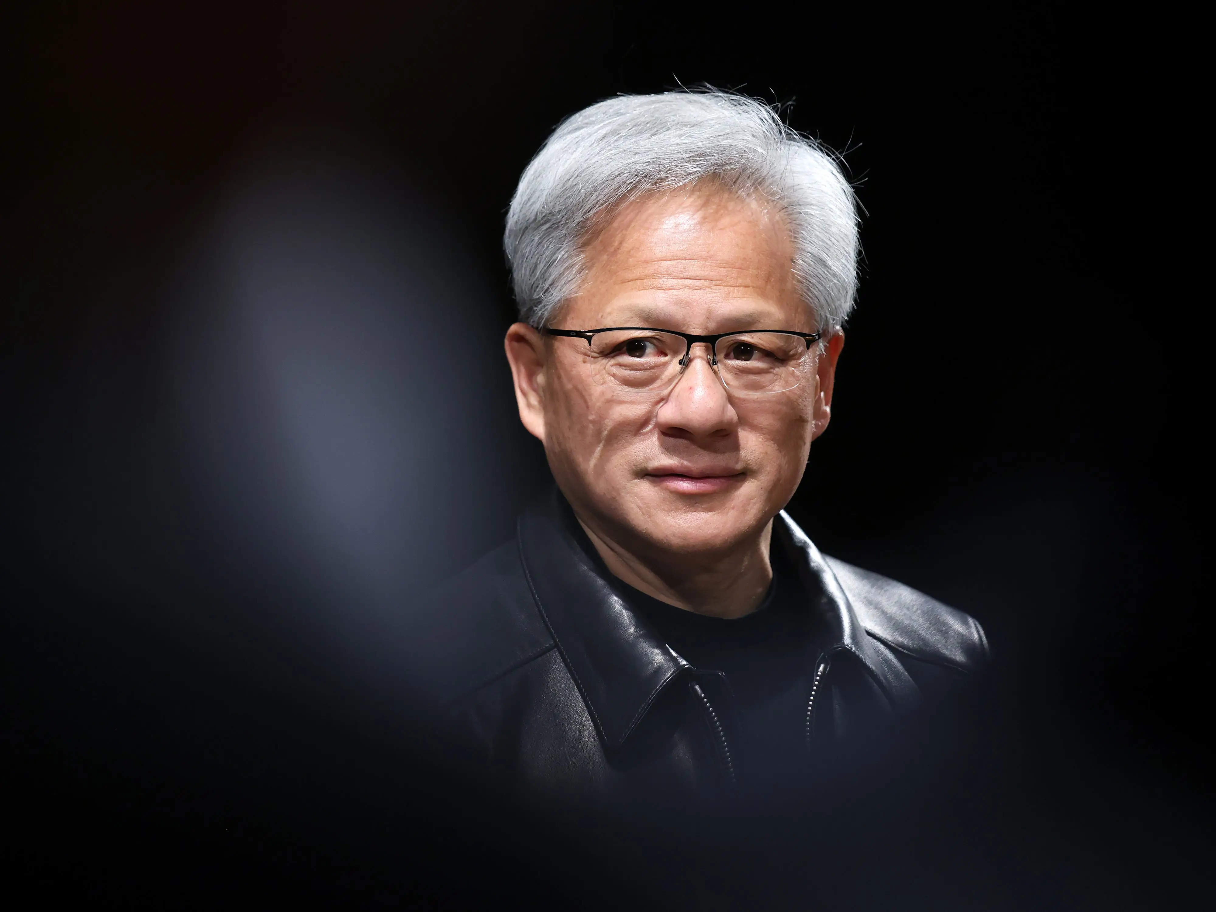 Nvidia founder and CEO Jensen Huang, surrounded by a black circular background.