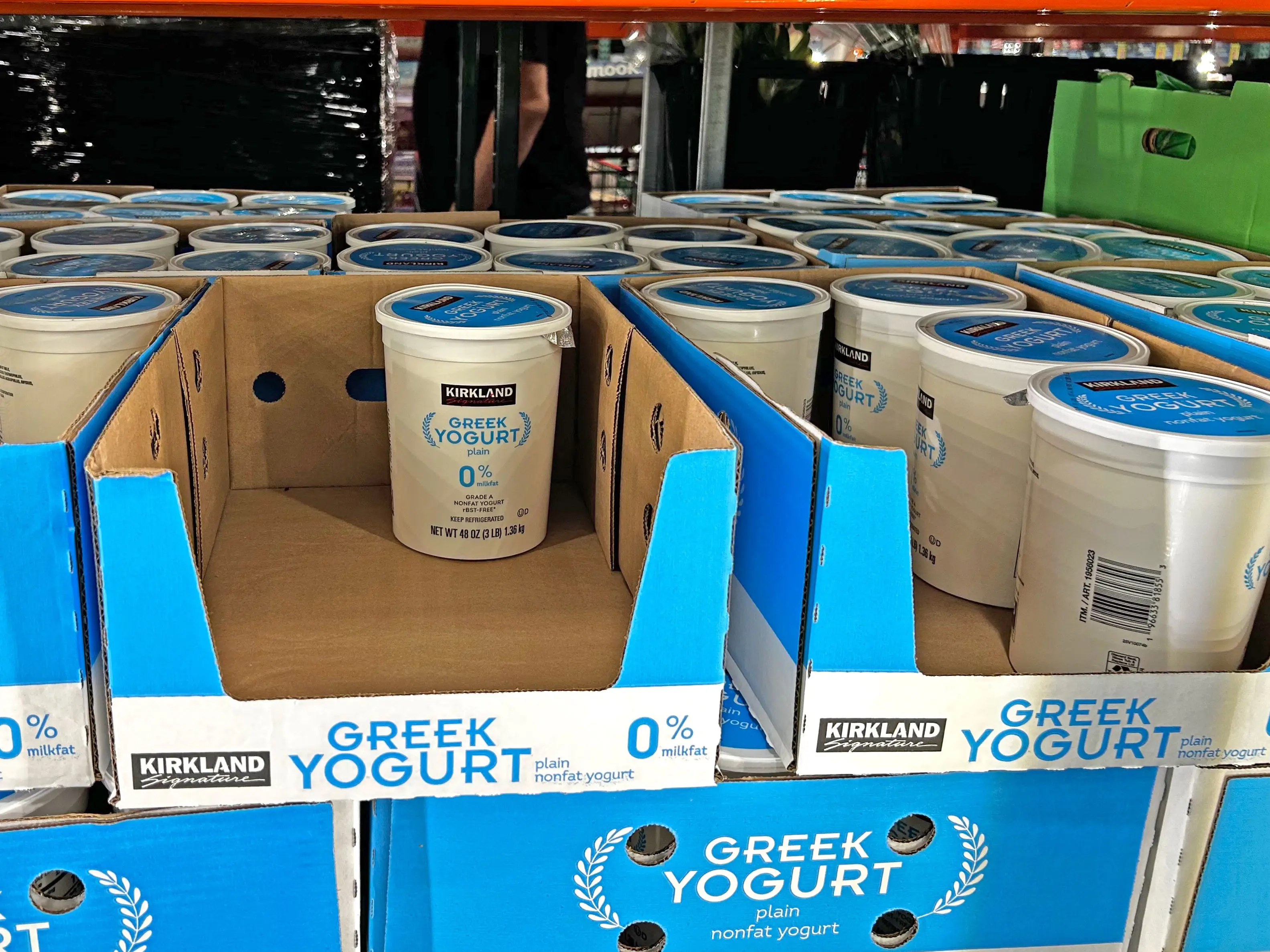 Containers of Kirkland Signature plain Greek yogurt in a refrigerator at Costco.