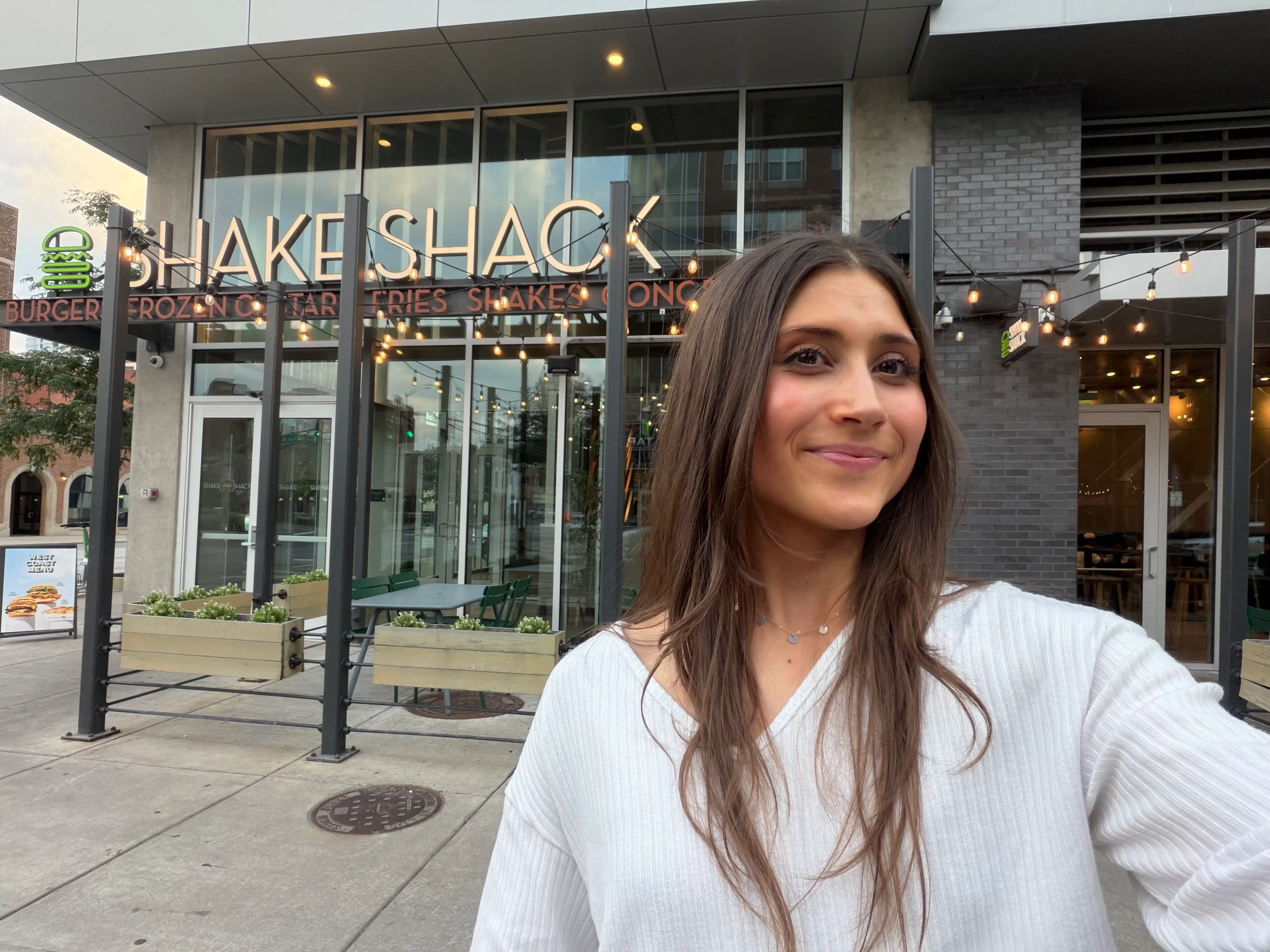Woman smiling in front of Shake Shack