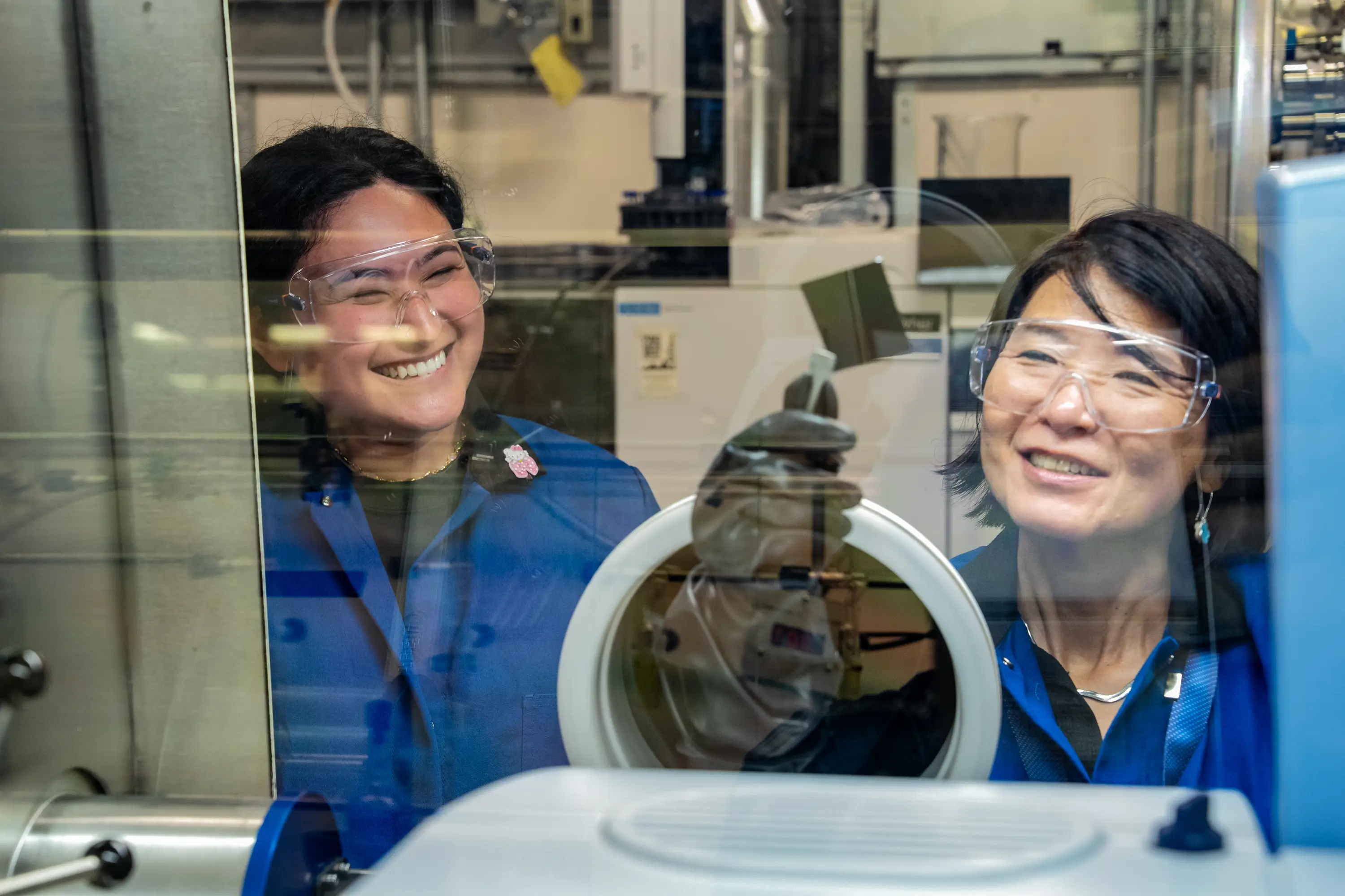 Myung-hee Na on the right holding a semiconductor tech device behind an enclosed container.
