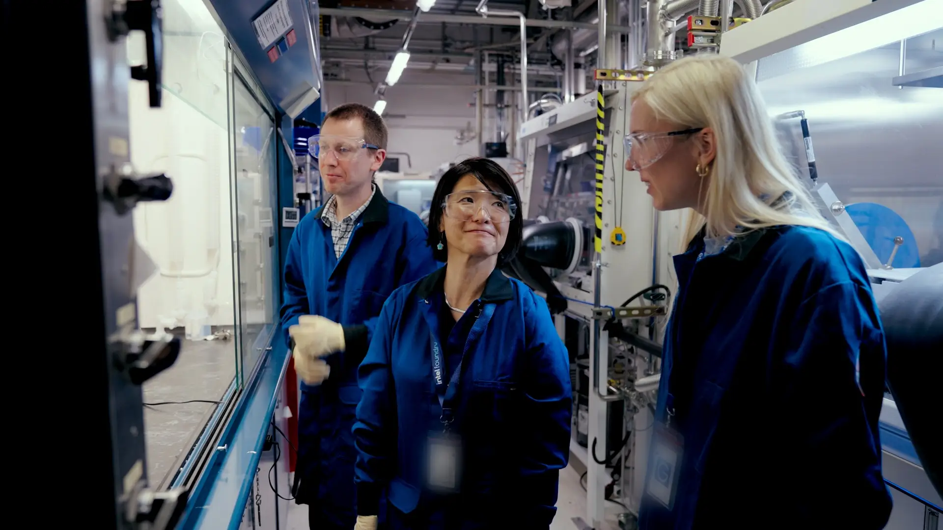 Intel lead researcher Myung-hee Na (middle) stands next to Business Insider producer Olivia Nemec inside of Intel Foundry's chip manufacturing facility.