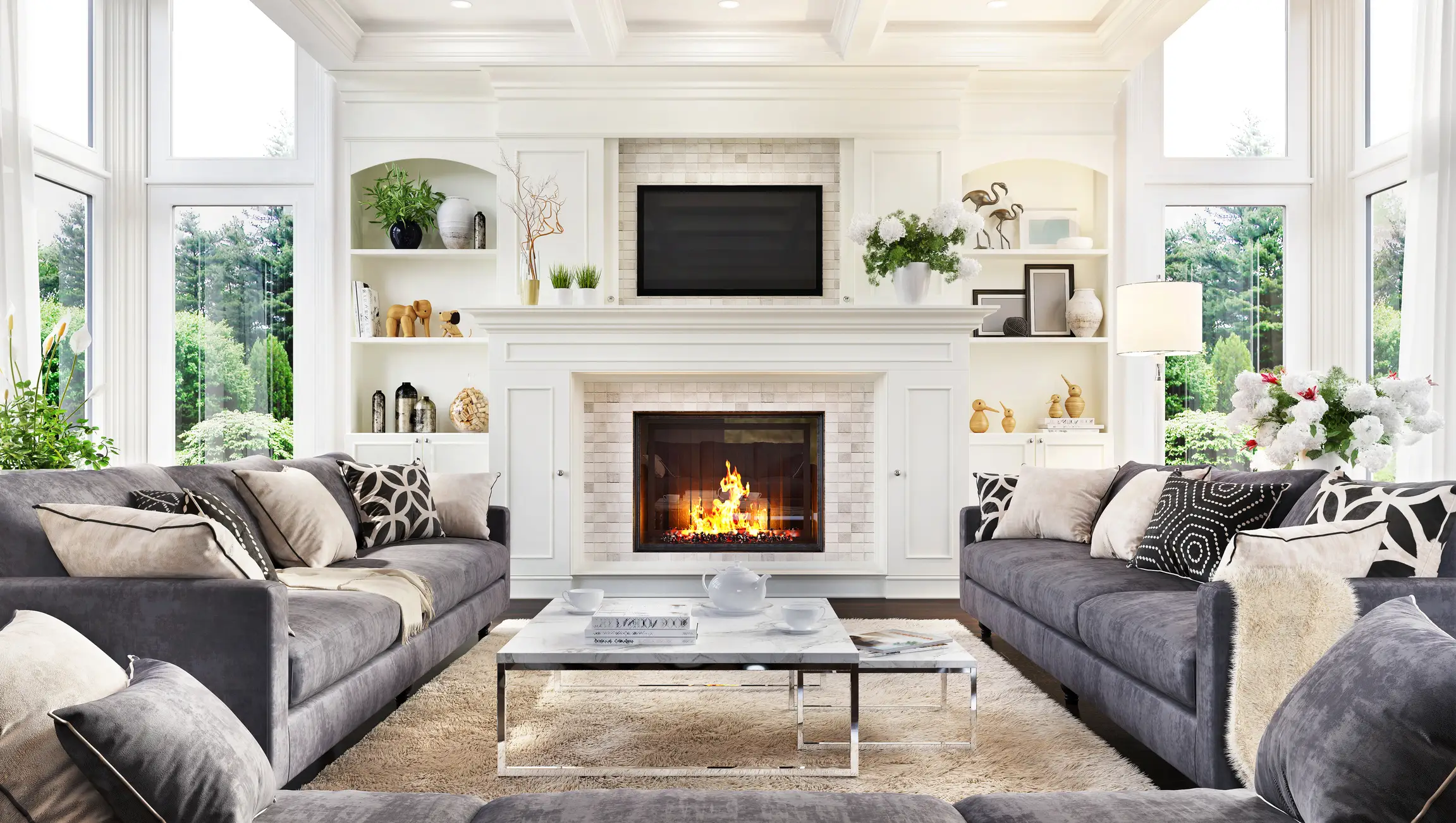 Living room with built-in shelves, white fireplace, gray couches