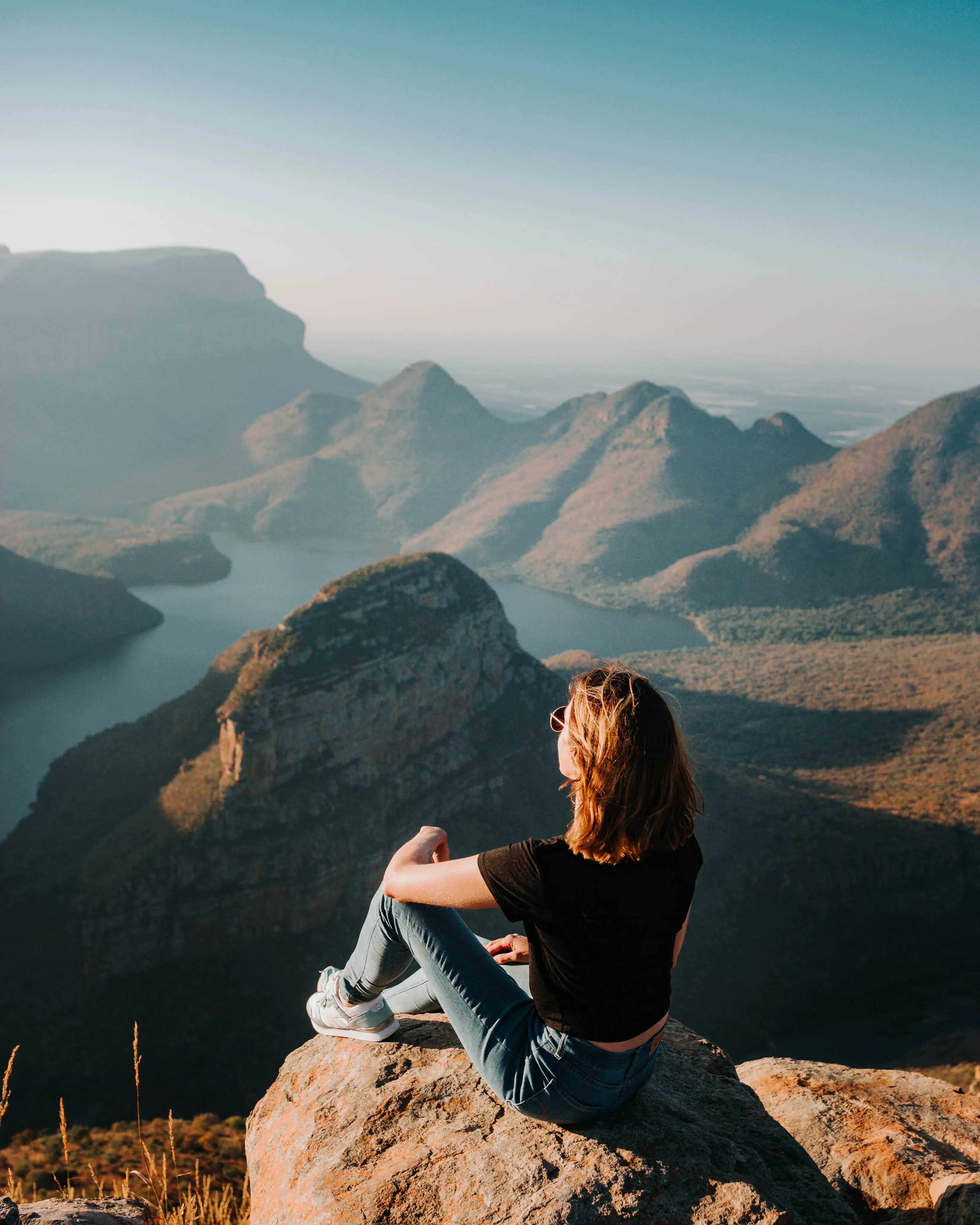 The author sitting on a rock overlooking a canyon and river.