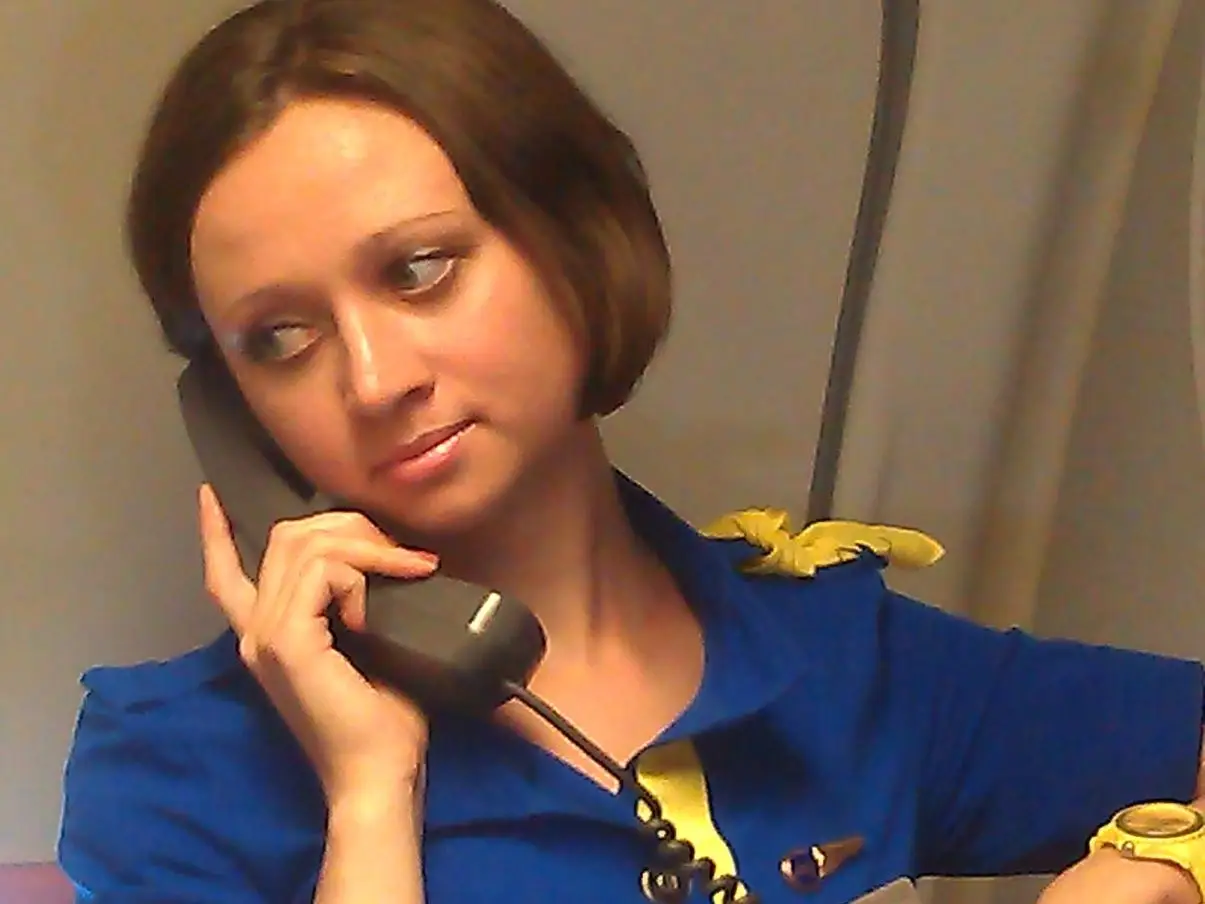 The author with a flight attendant phone and a yellow watch on.