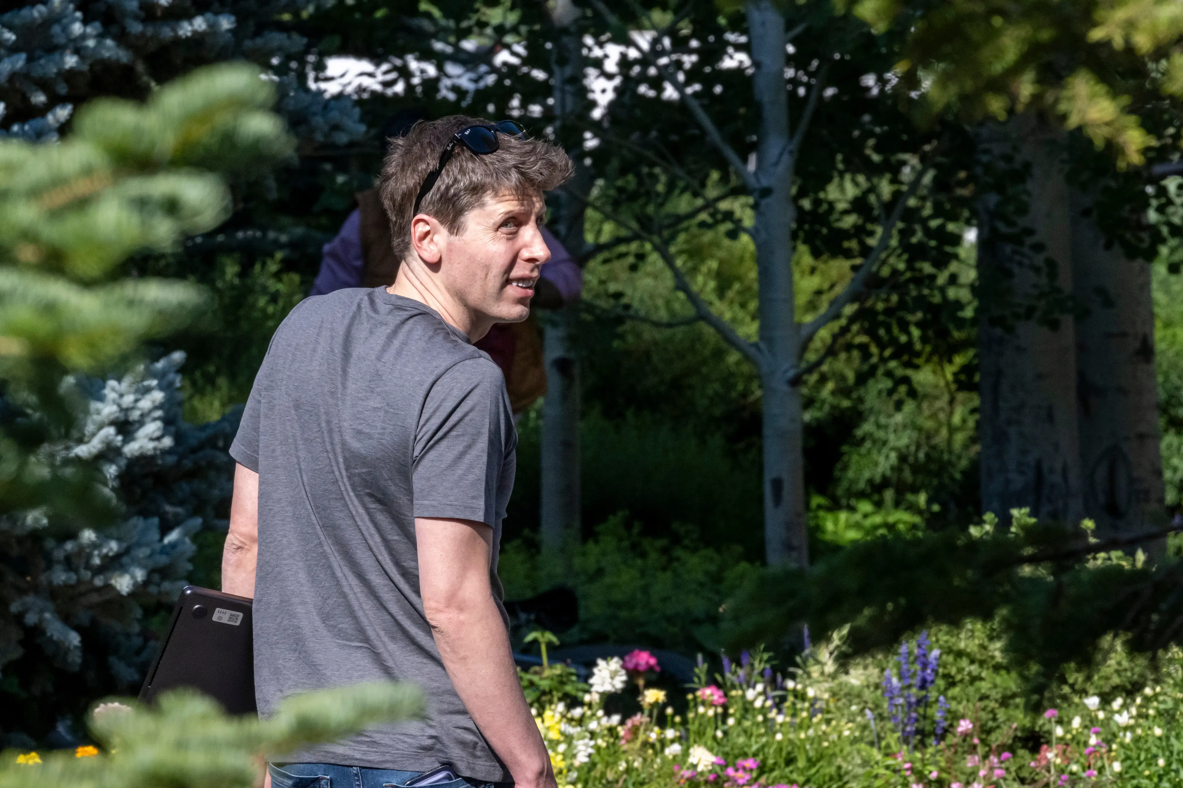 OpenAI CEO Sam Altman walks through a park in Sun Valley, Idaho.