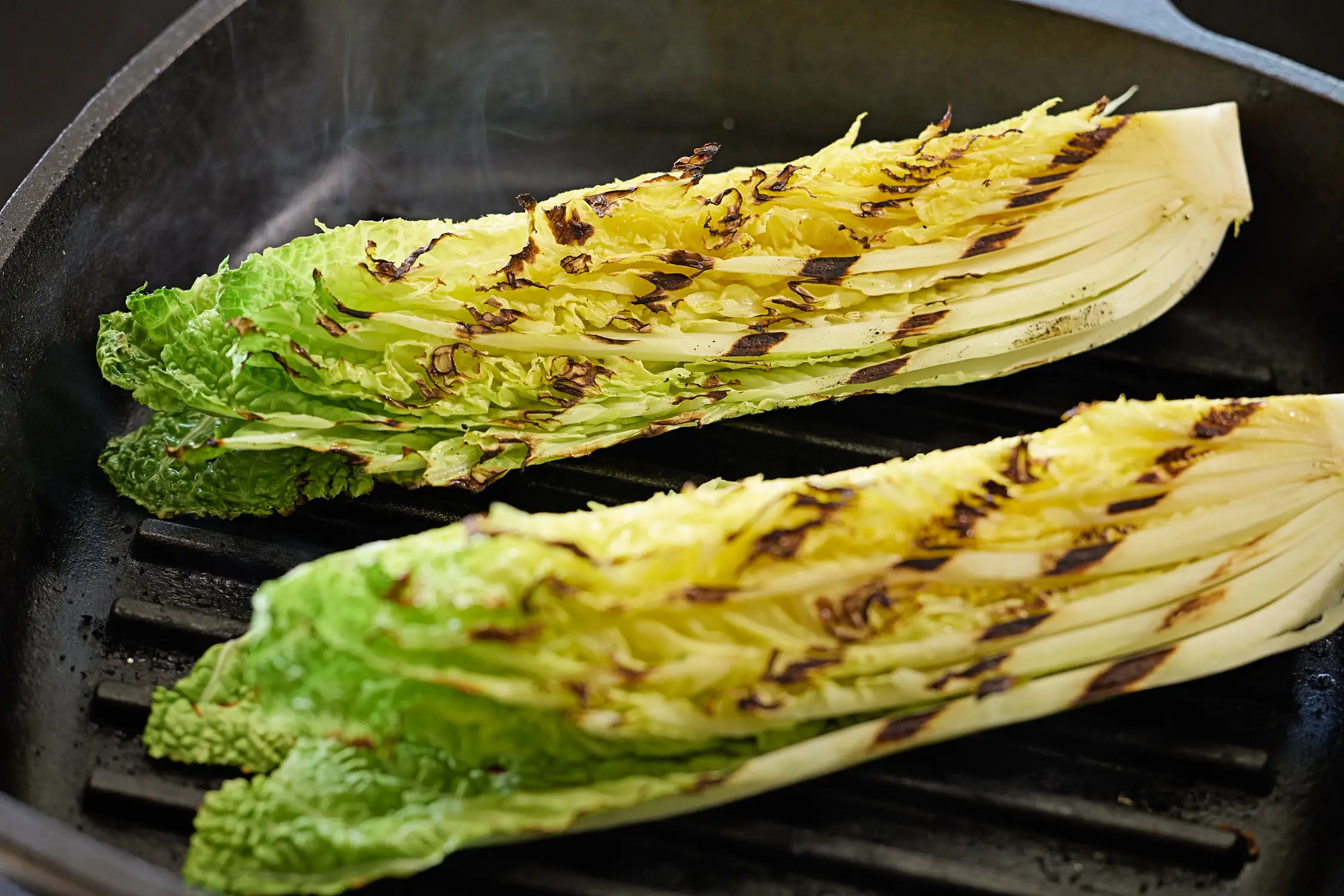 Grilled cabbage sizzling in a pan.
