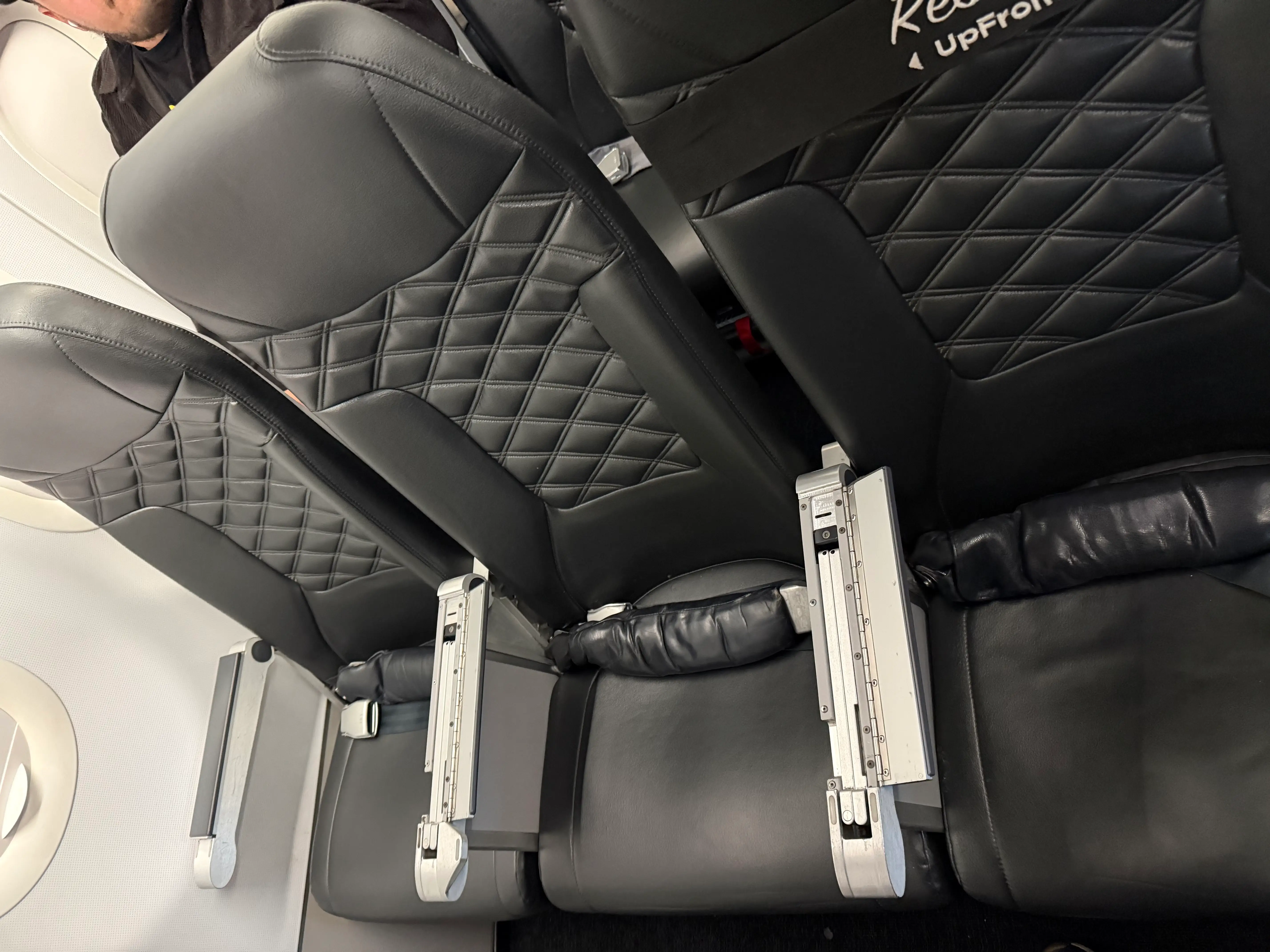 Row of leathery black seats in Frontier UpFront row