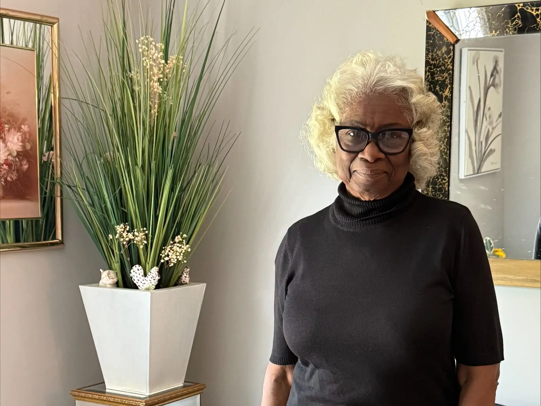 a woman poses in front of her couch