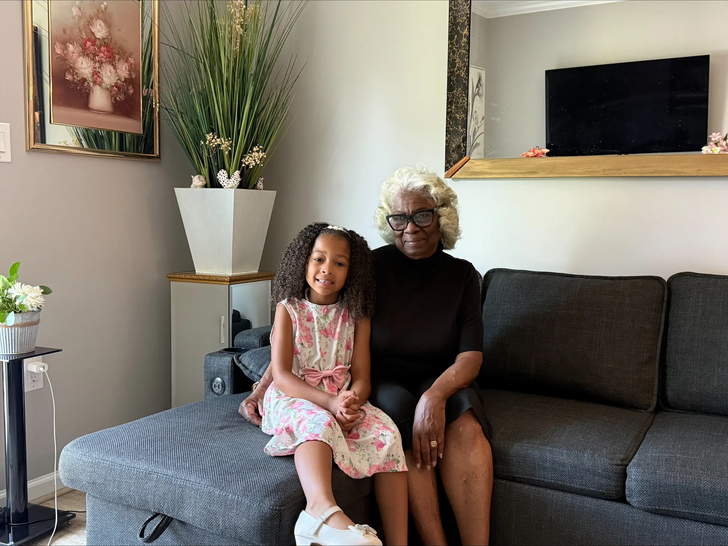 a woman poses with her granddaughter