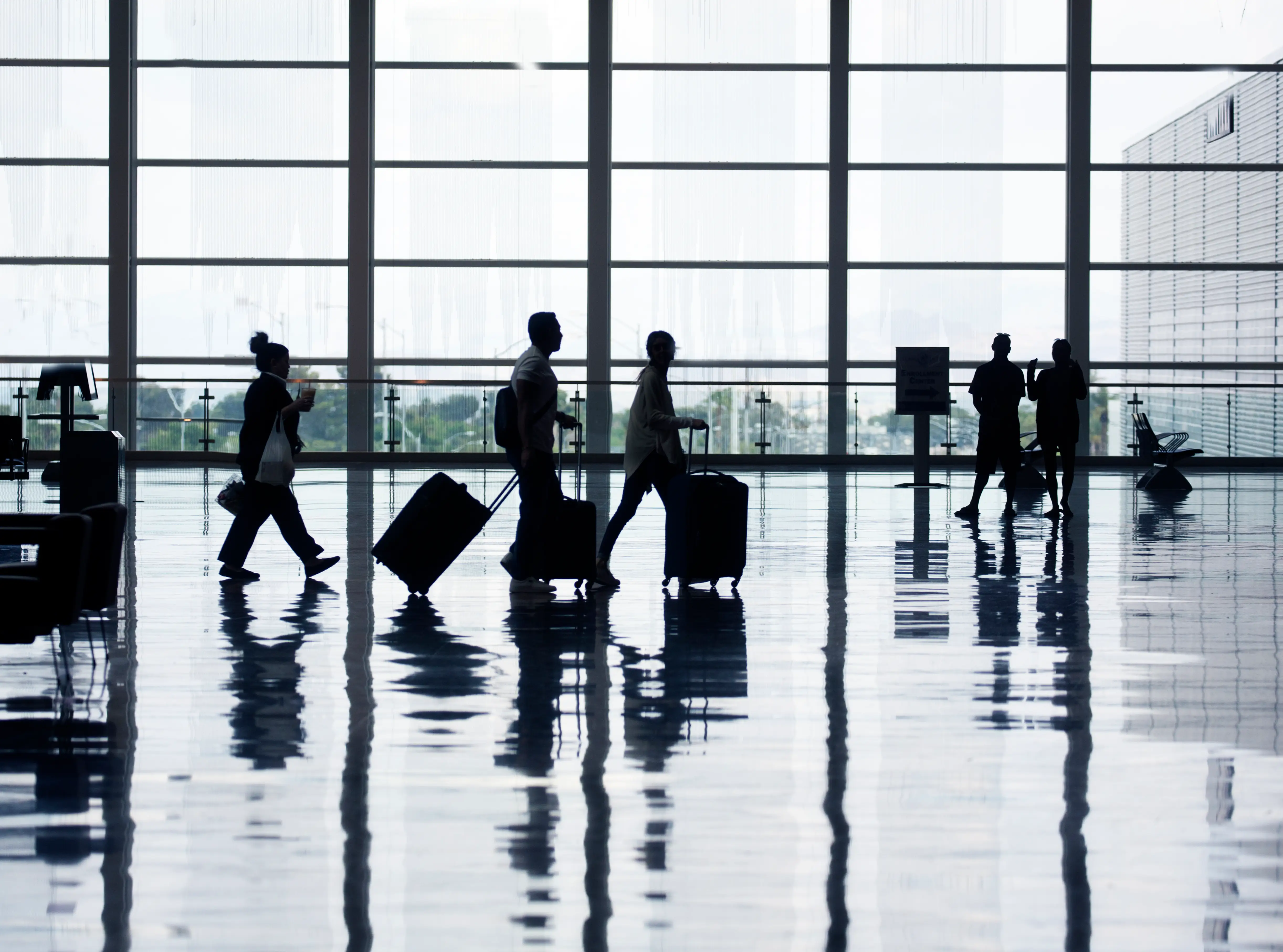 people with suitcases walking through airport