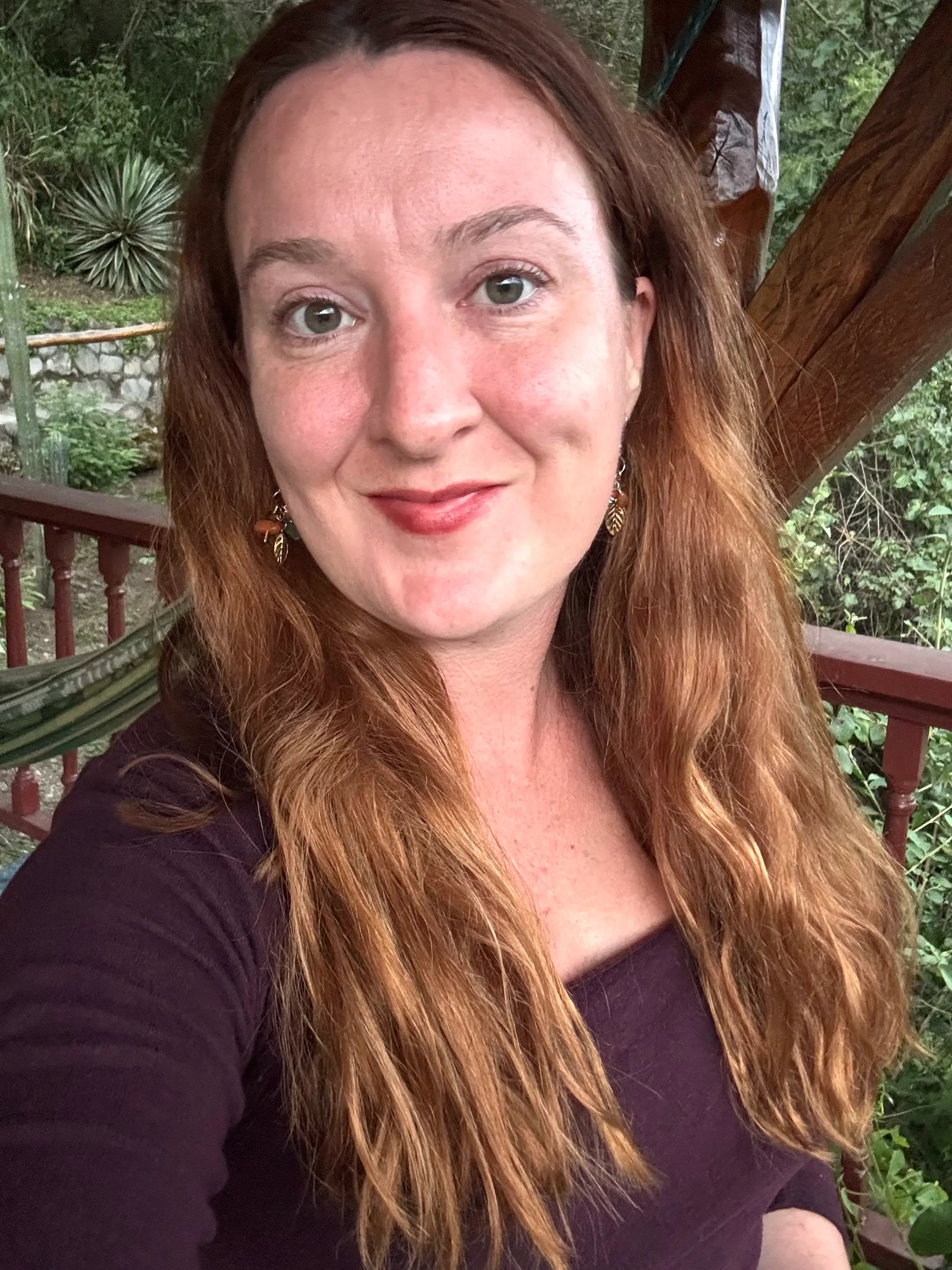 A woman's face wearing a dark top.