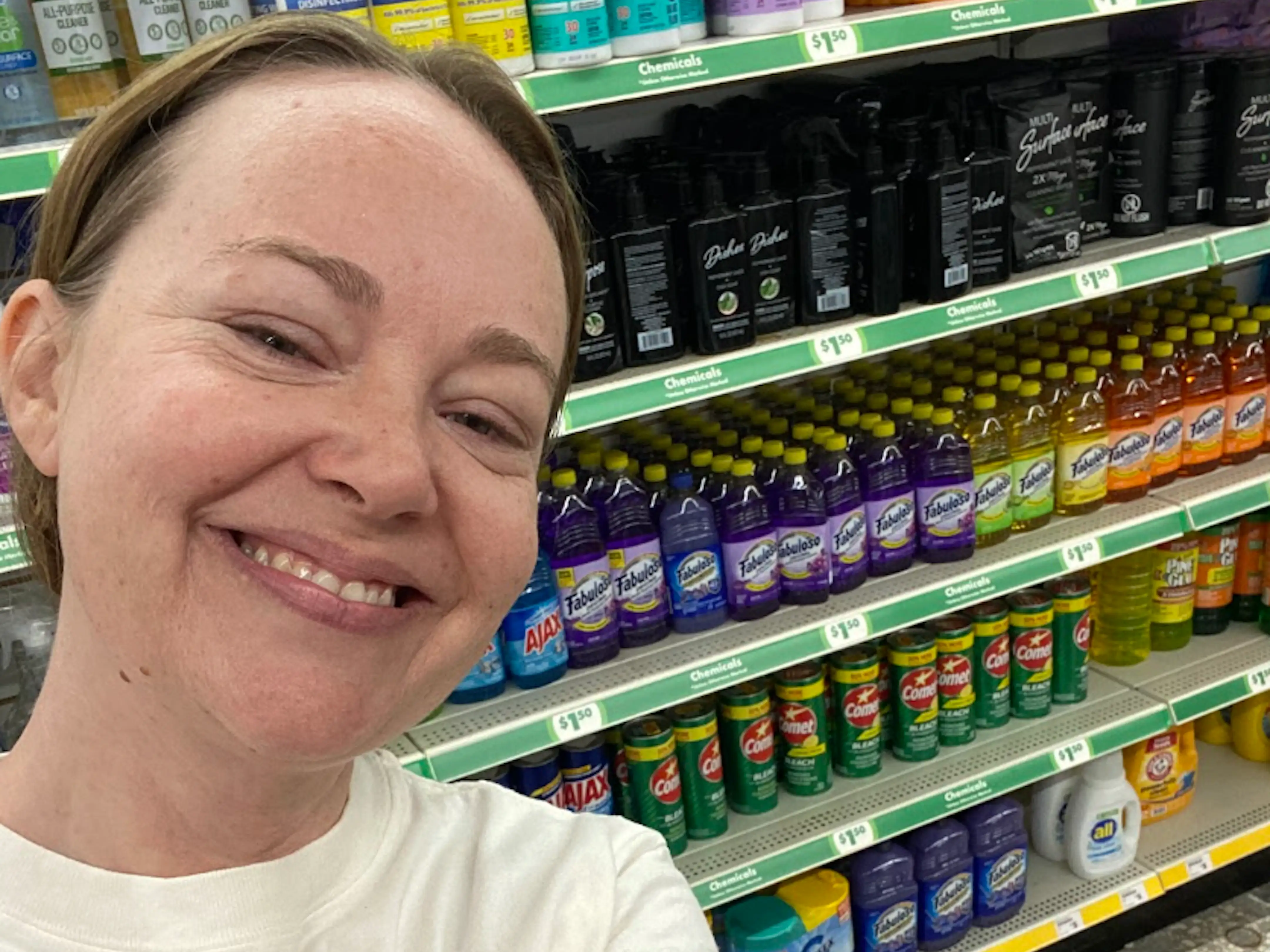 The writer standing in front of a cleaning-supplies aisle at Dollar Tree.