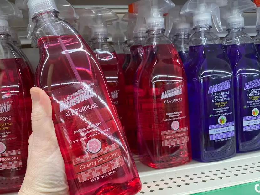 A hand holding a red bottle of LA's Totally Awesome all-purpose cleaner.