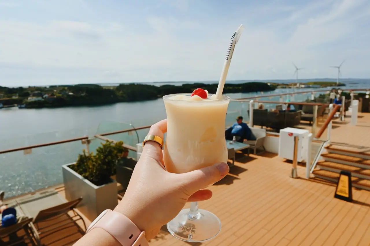 Hand holding cocktail on Celebrity cruise ship