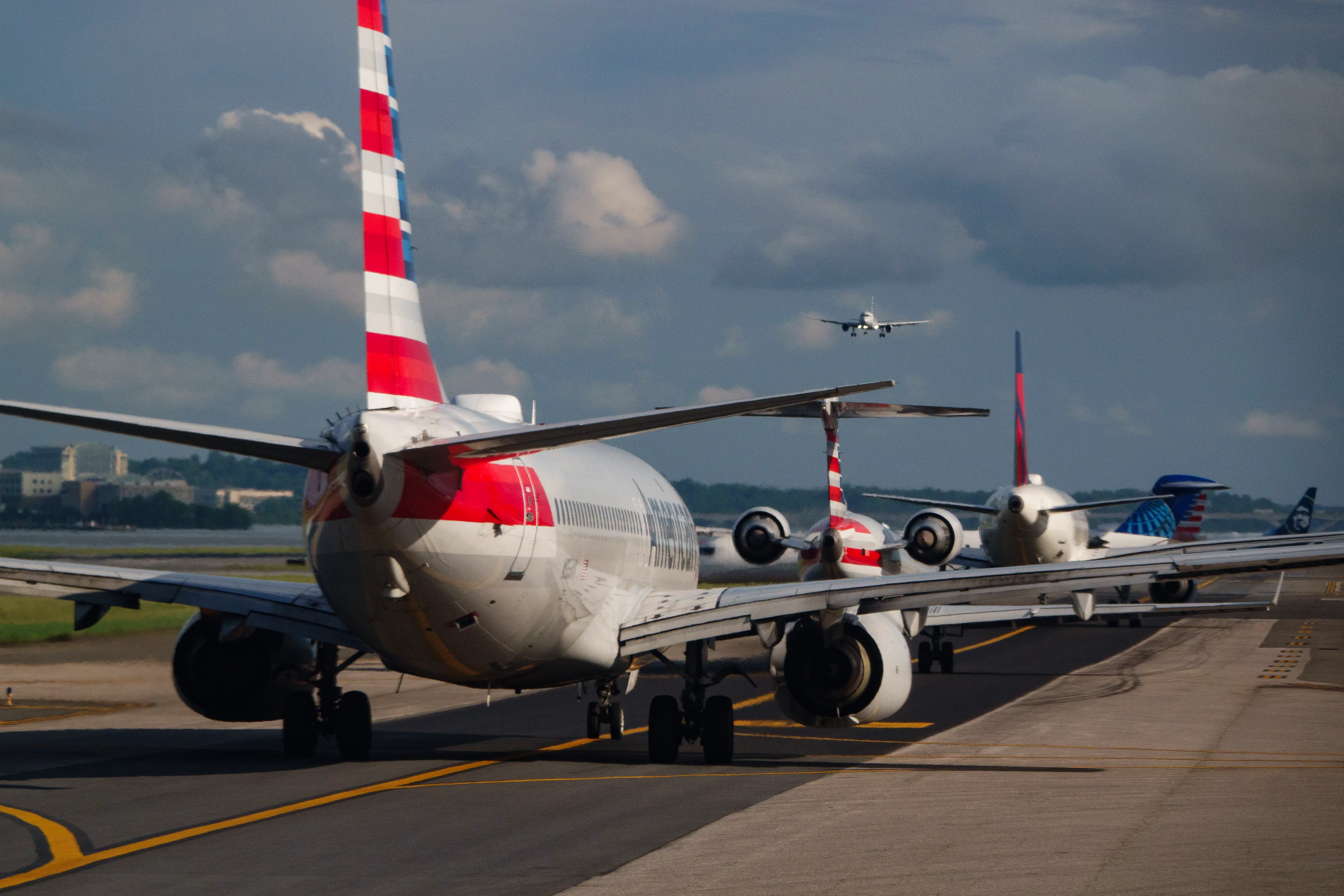 A line of airlines waits on an airport tarmac.