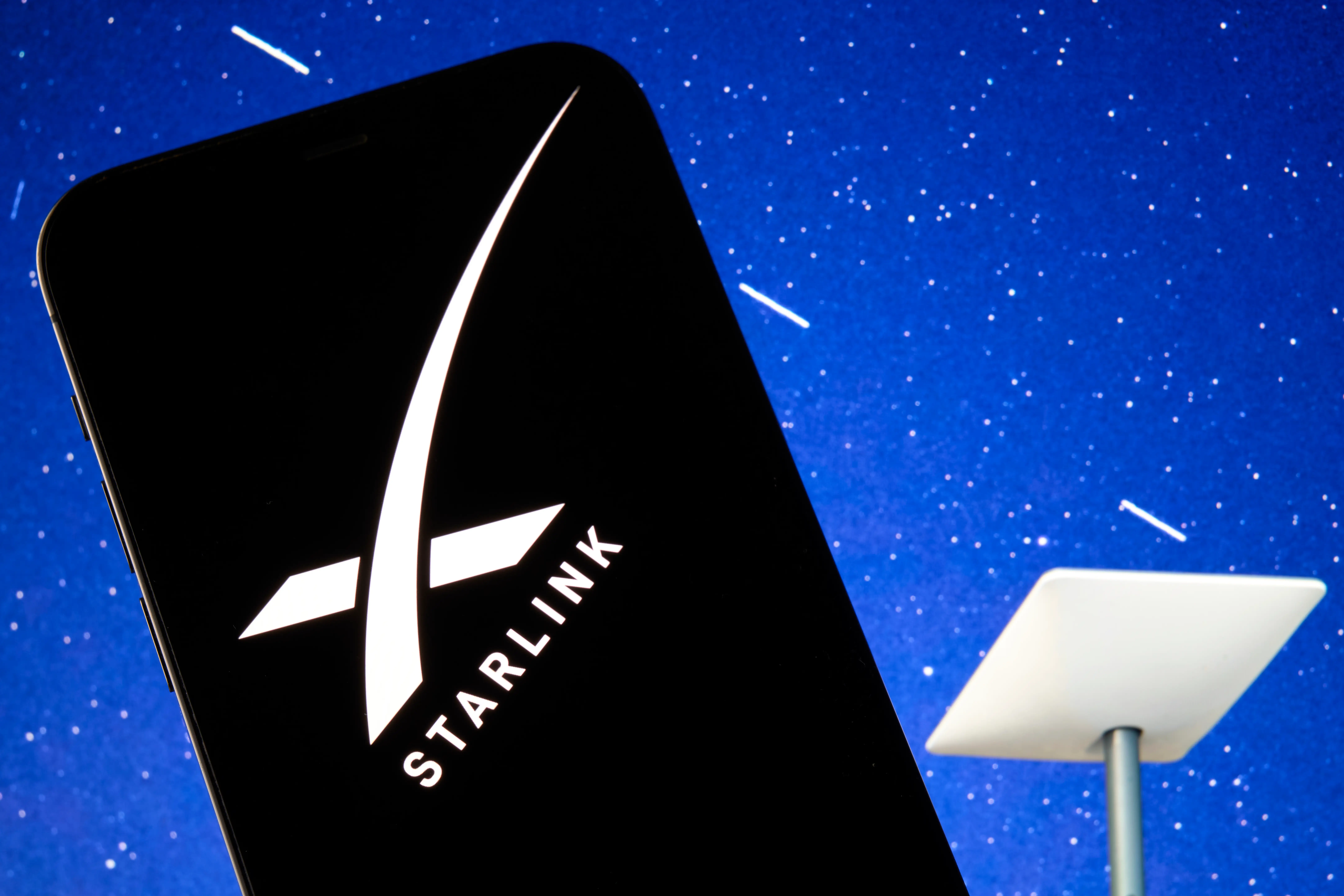 Smartphone showing Starlink logo and a space like background