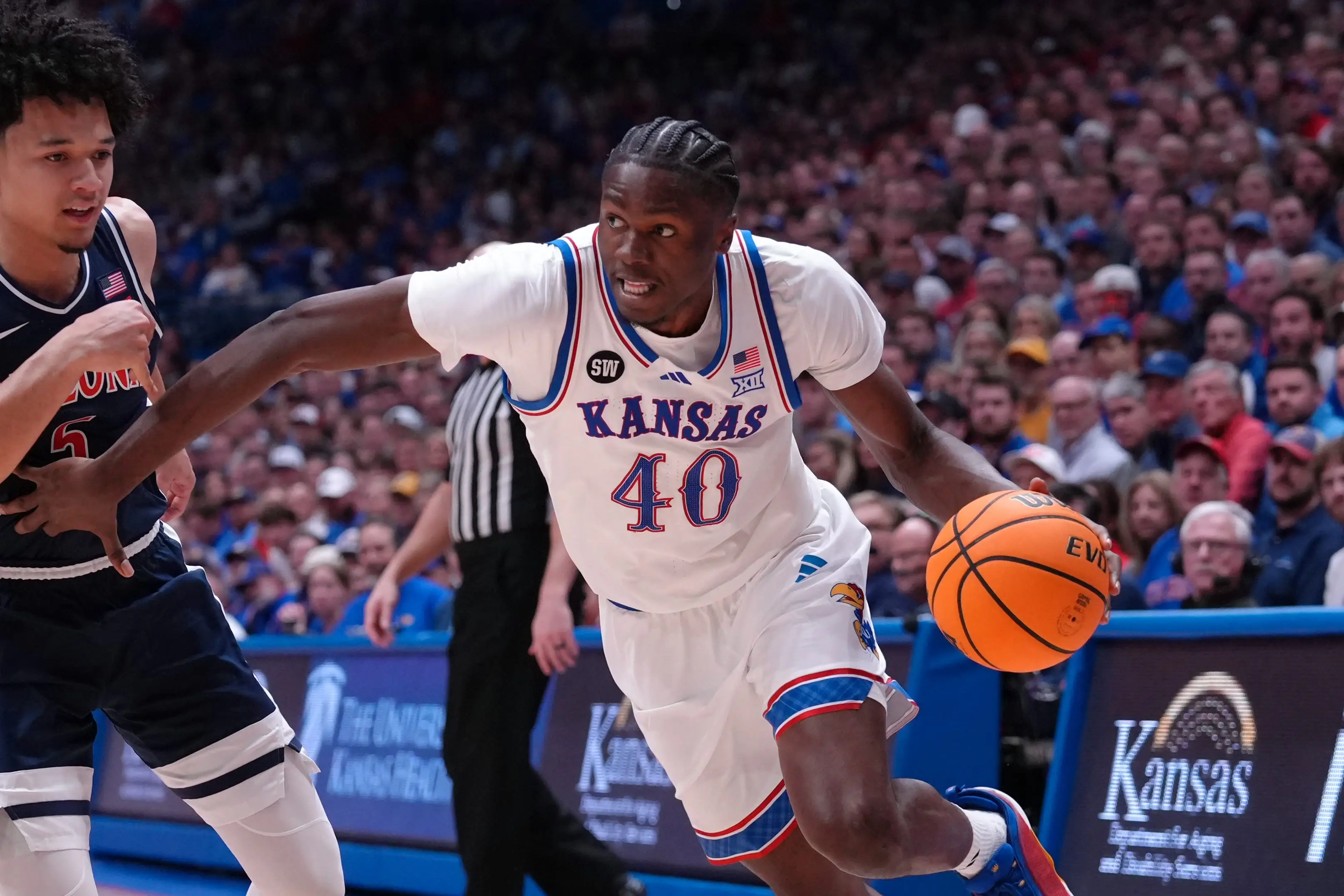 Forward Flory Bidunga #40 of the Kansas Jayhawks drives against guard Brayden Burries #5 of the Arizona Wildcats in.