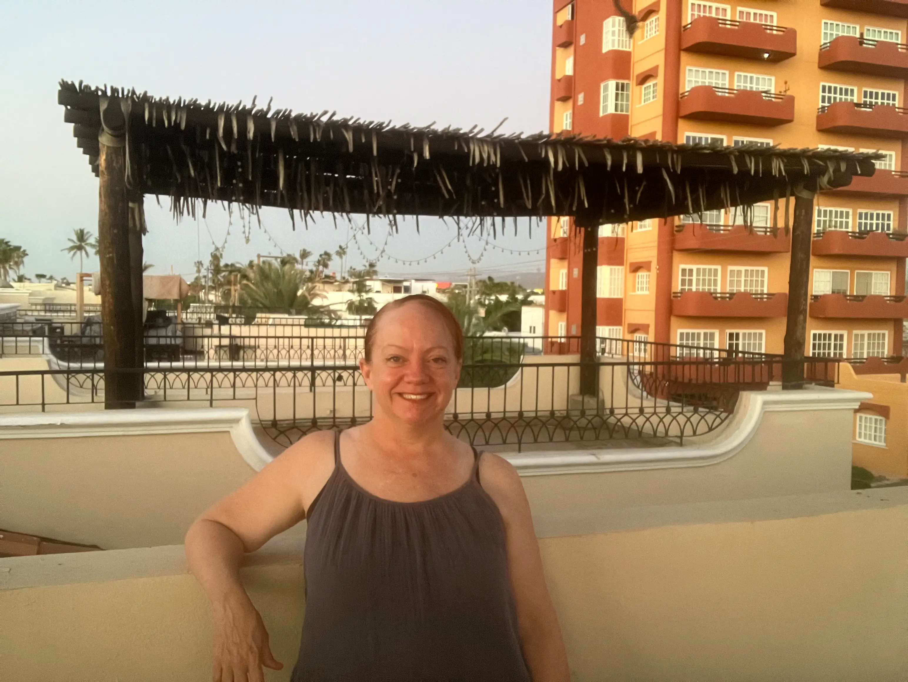 Woman smiling in front of covered structure, building