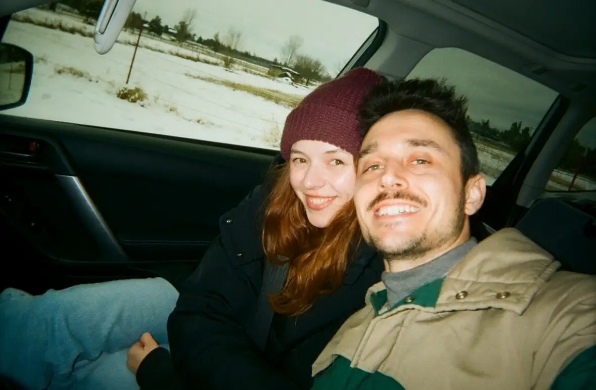 Man and woman taking selfie in car