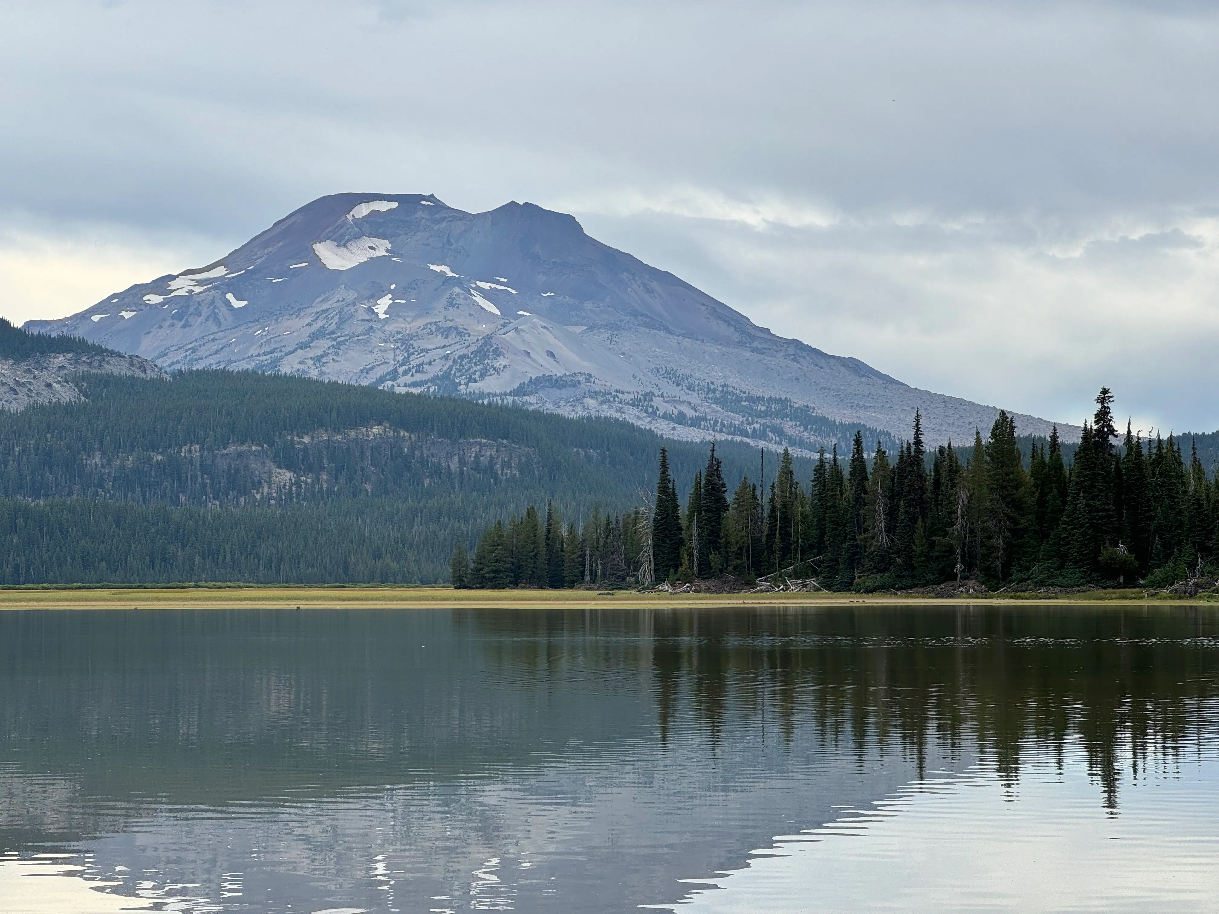 Trees next to mountains, water in Bend