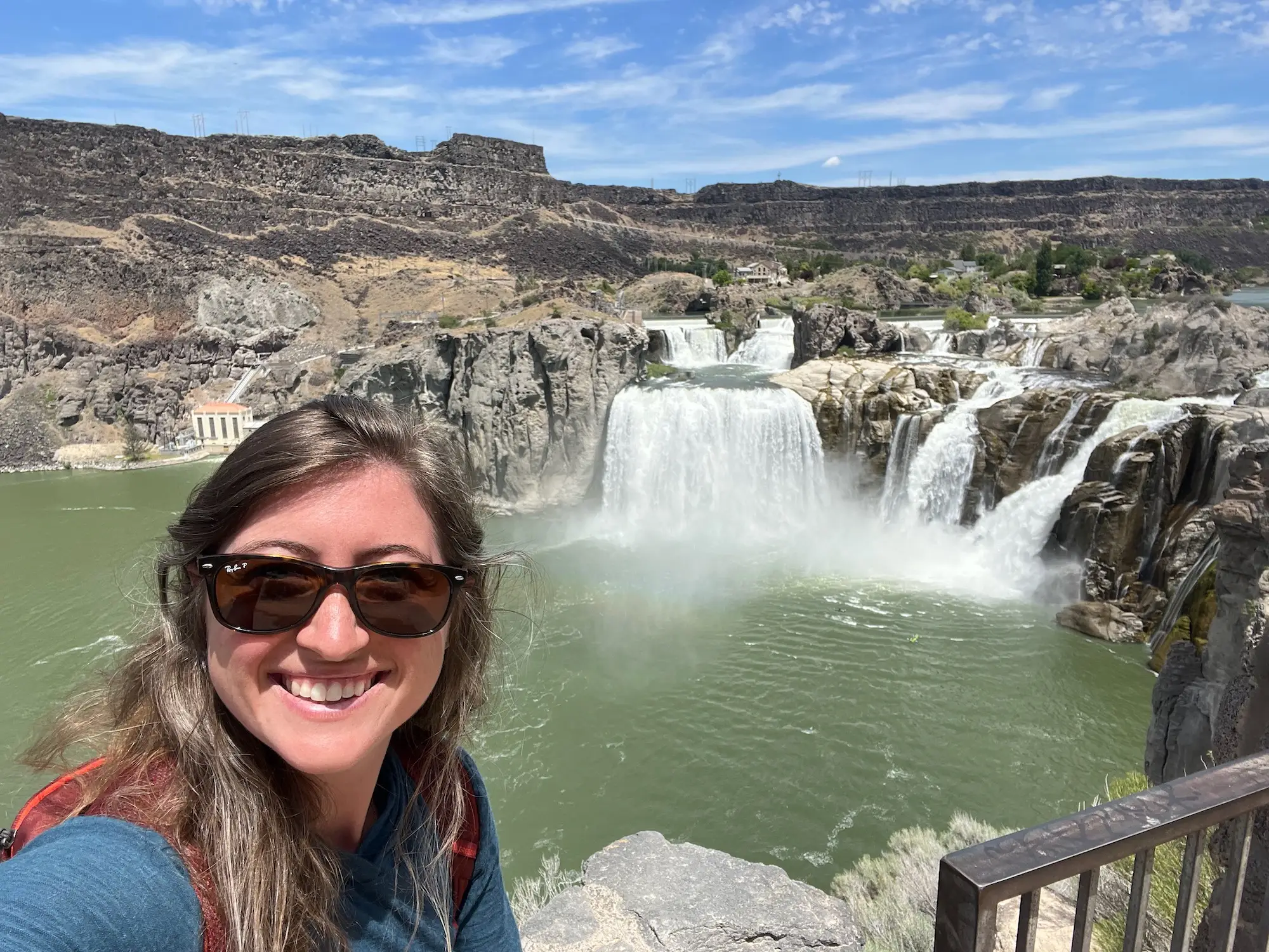 The author poses in front of a waterfall while on a solo trip cross-country.