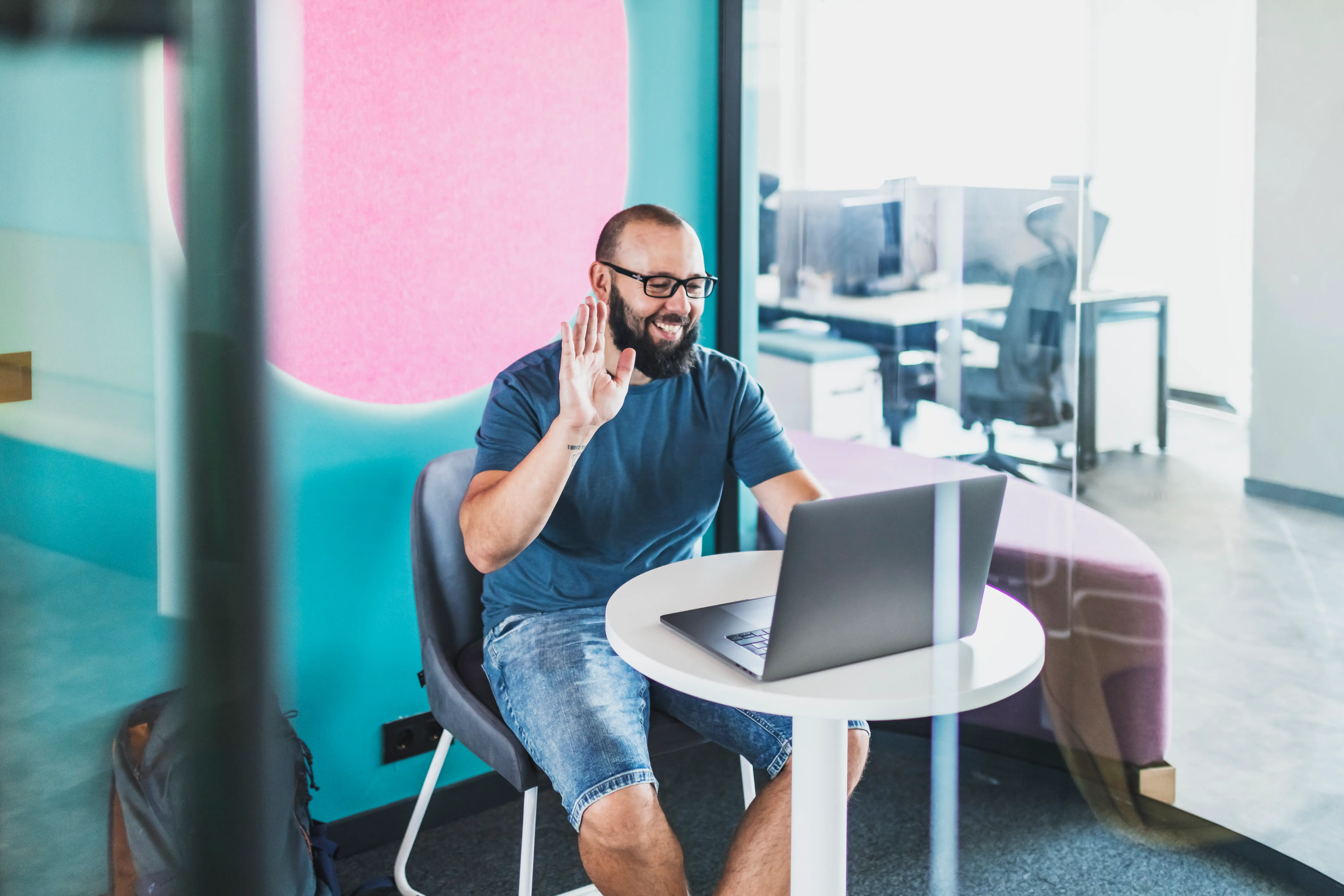 A man wearing jean shorts in an office environment