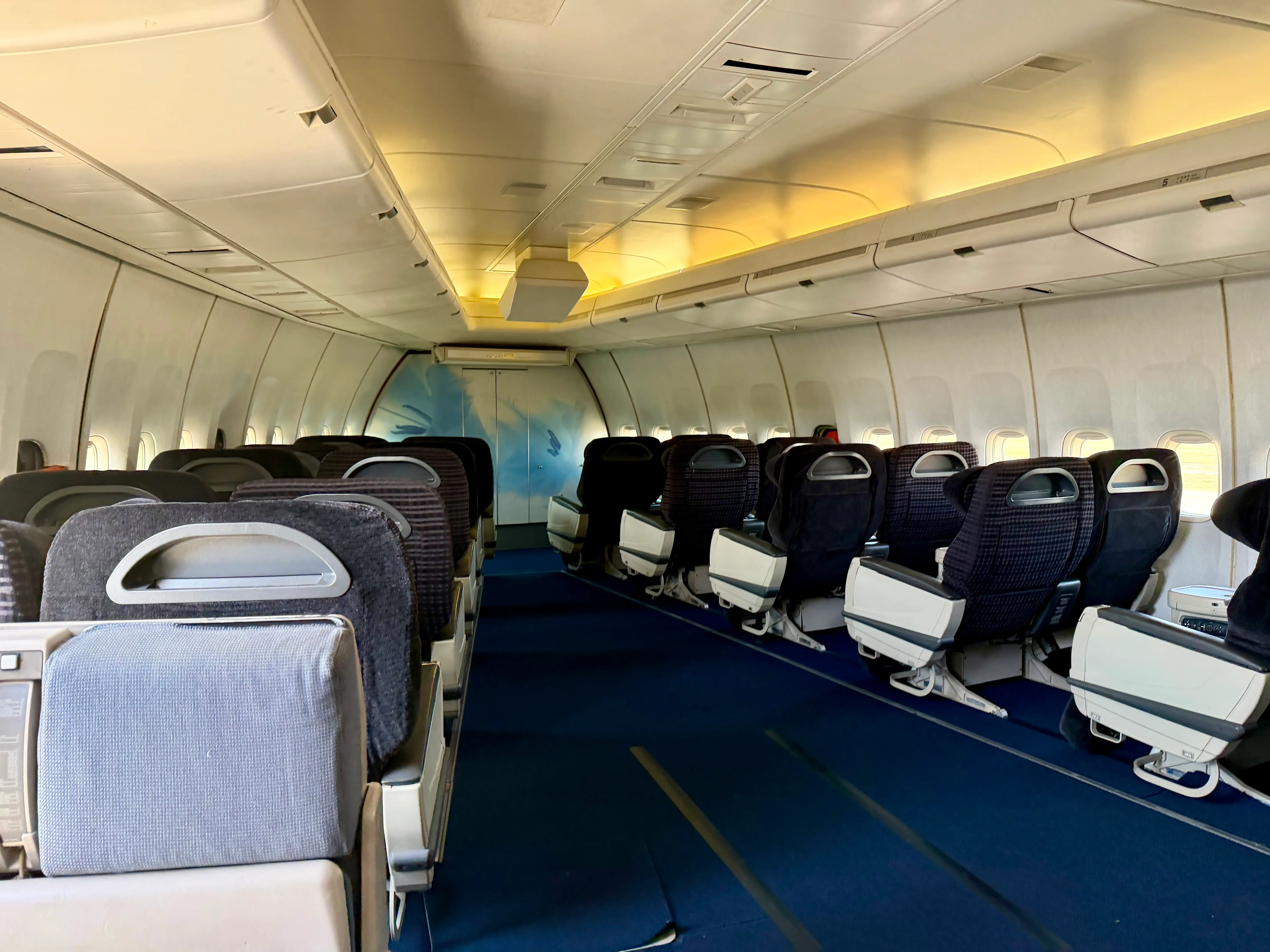 The business class section of the GE 747 testbed, with over a dozen gray recliners.