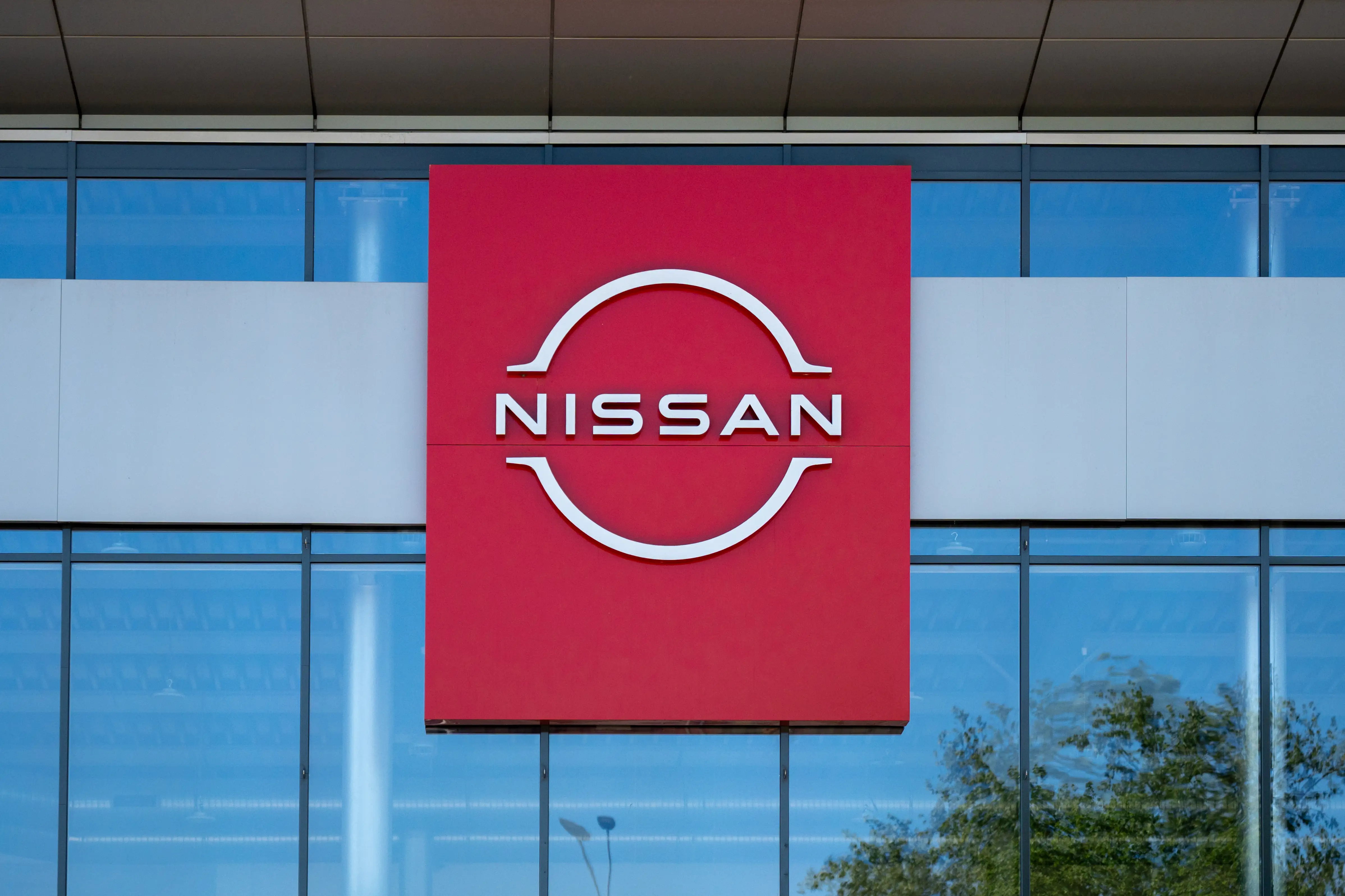 A Nissan dealership with a large red Nissan sign.