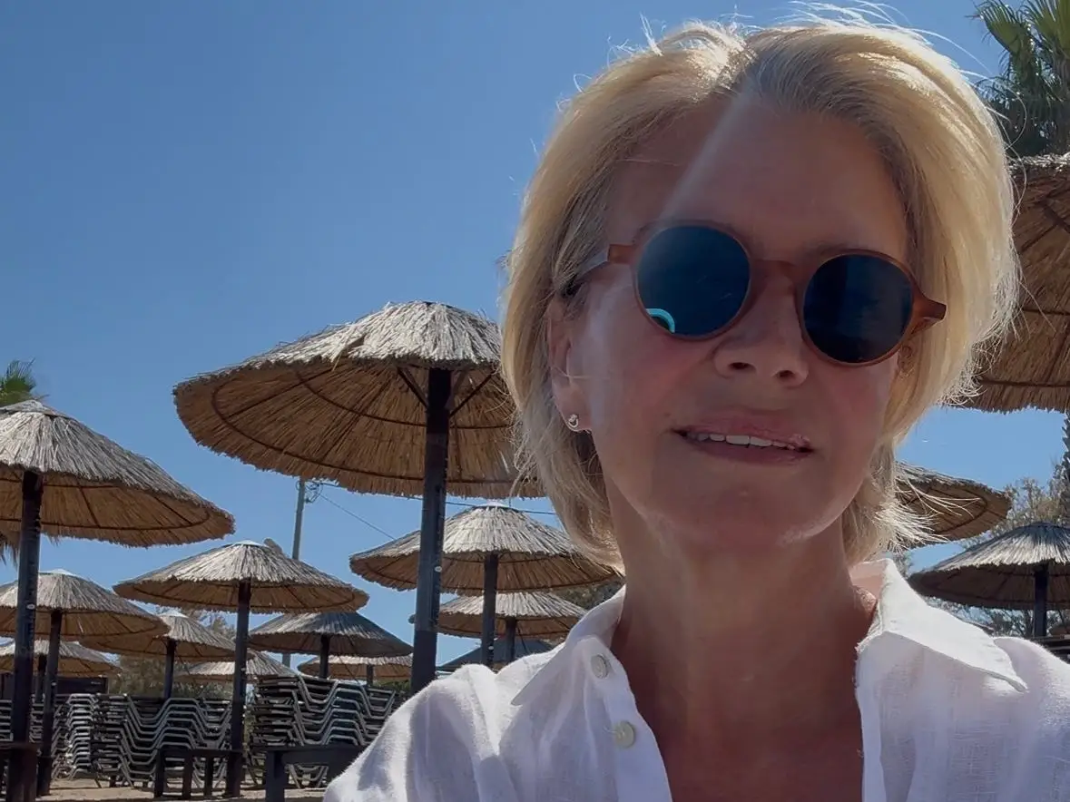 A woman on a beach wearing sunglasses.