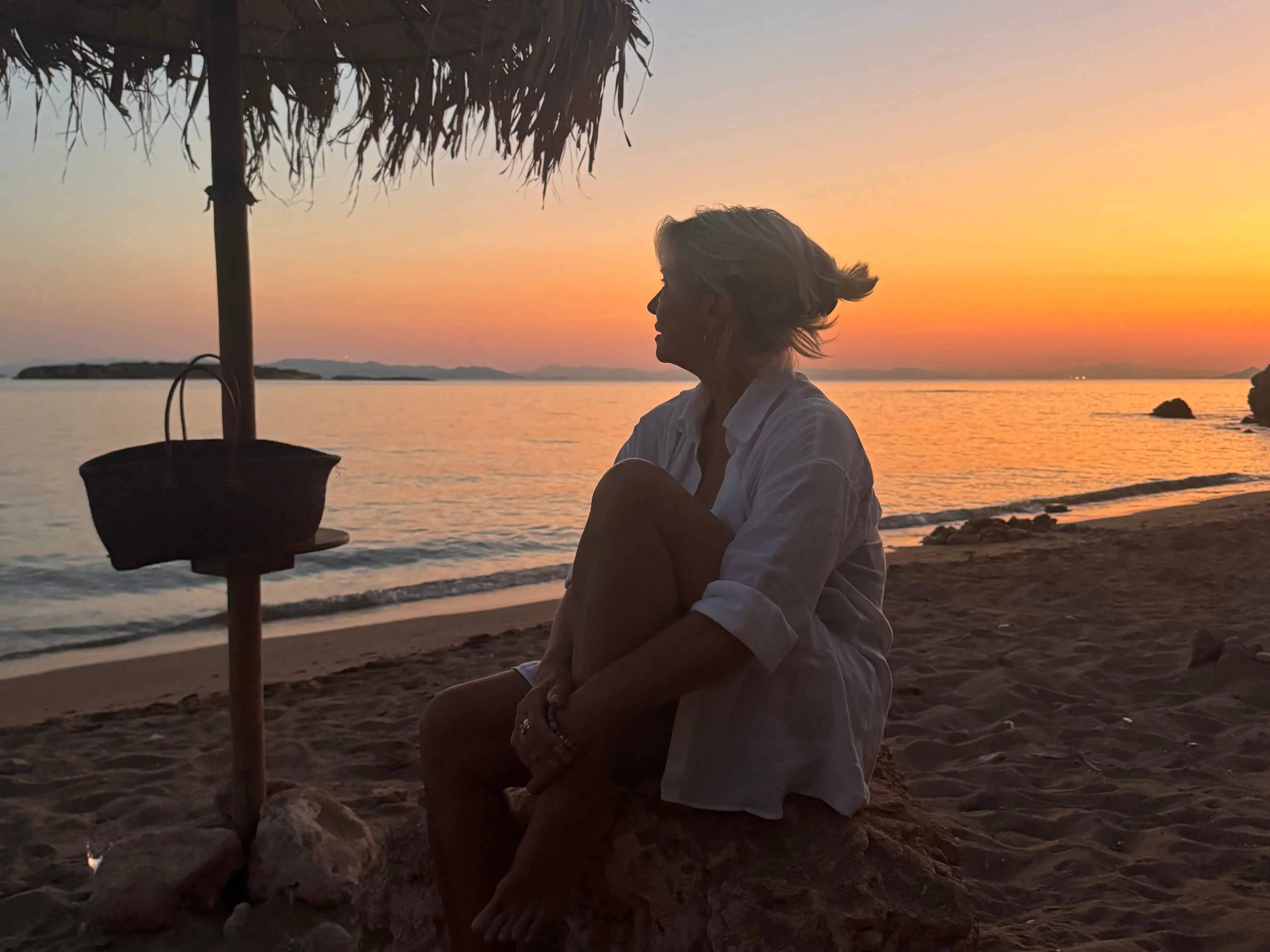 A woman on a beach at sunset