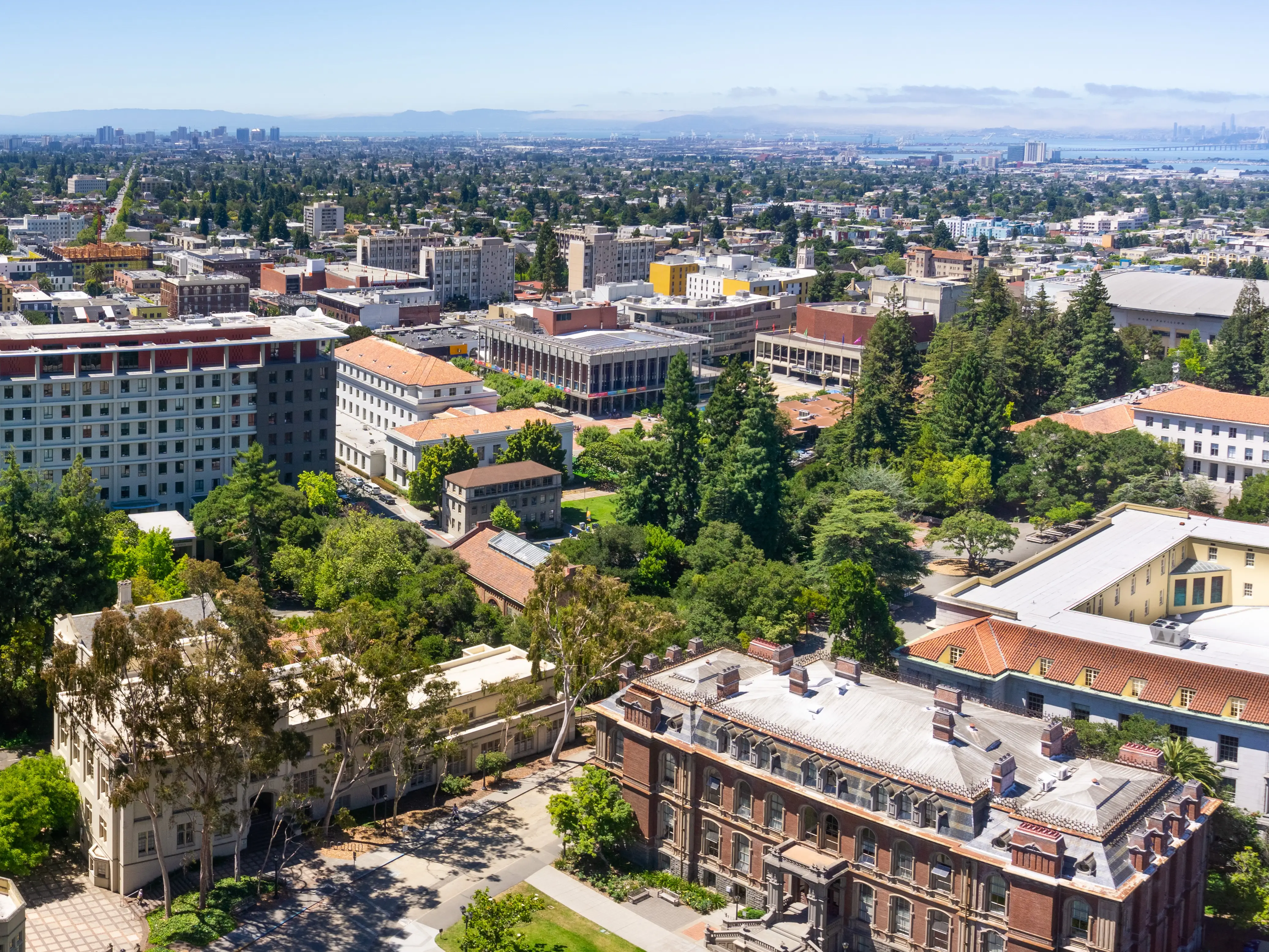 Panoramic view of UC Berkeley on a sunny day, view towards Oakland and the San Francisco bay shoreline in the background, California