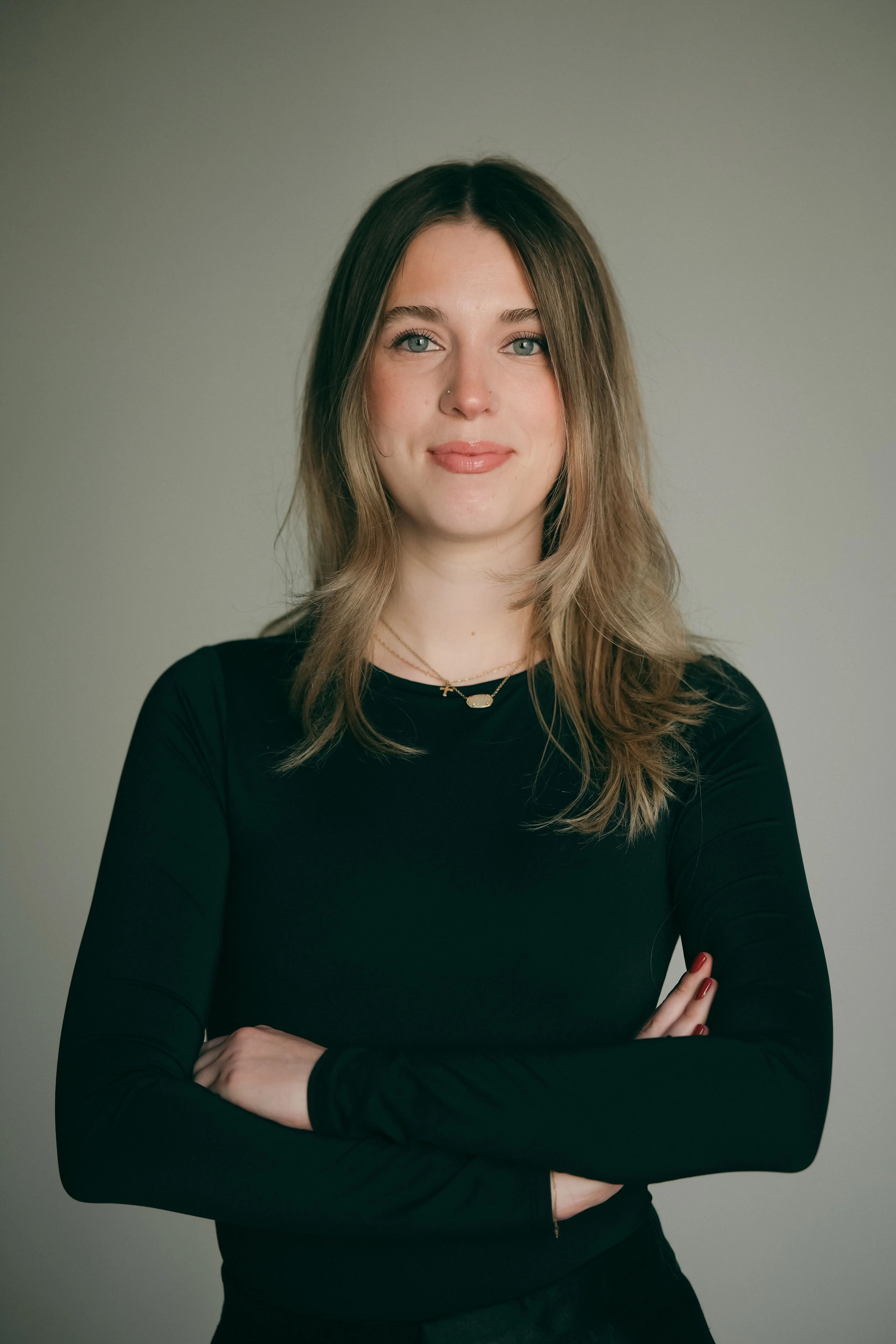 a woman poses with her arms crossed