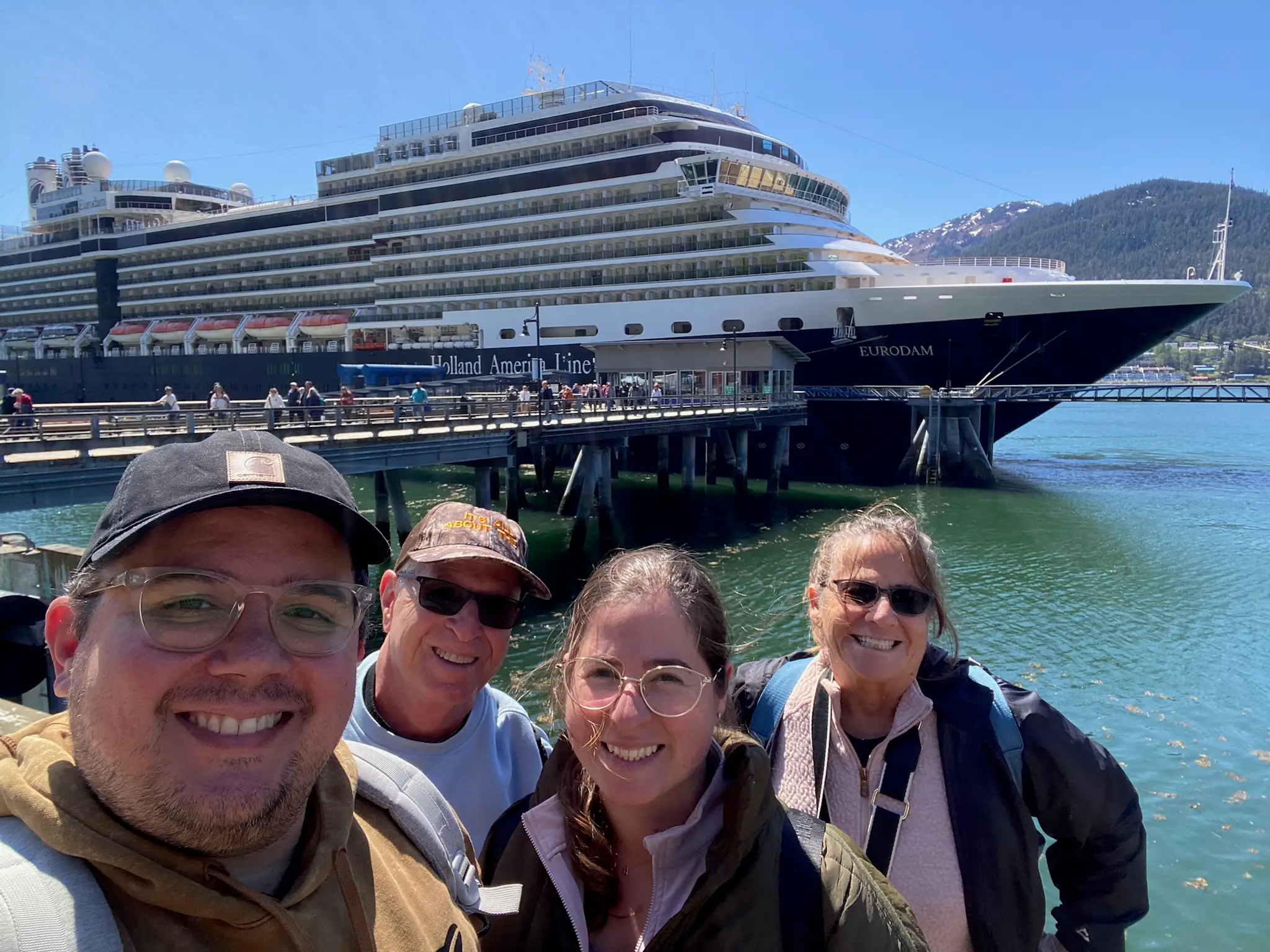 Group of four smiling in front of cruise shp