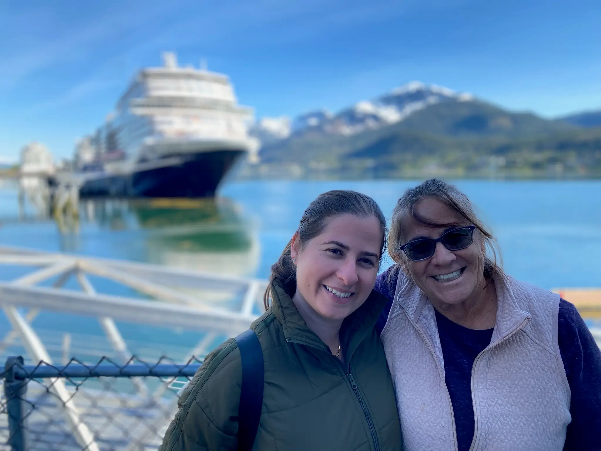 Woman and her mom smiling with cruise ship in distance