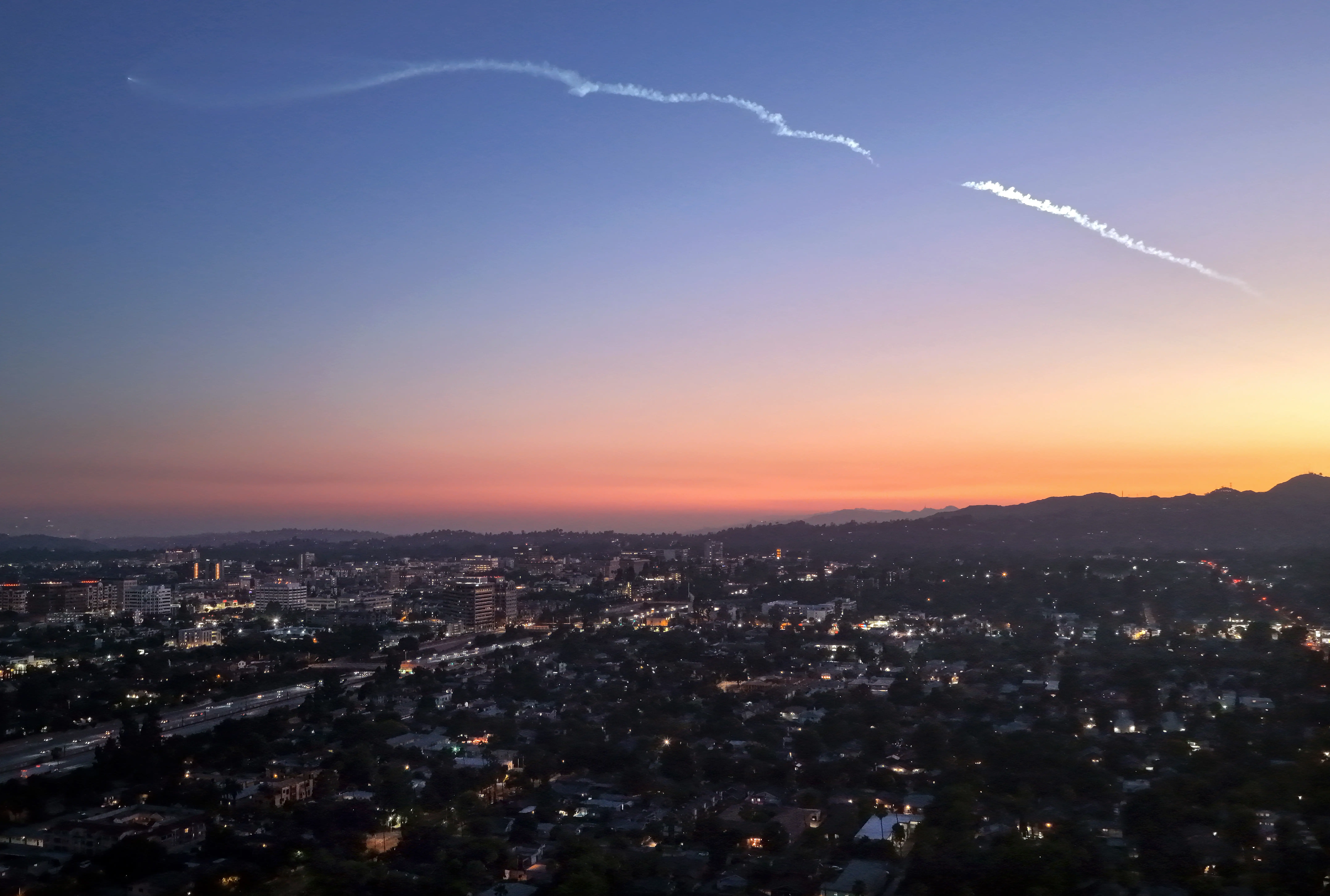 An aerial view of a SpaceX Falcon 9 rocket carrying Starlink satellites streaks over Pasadena, California.