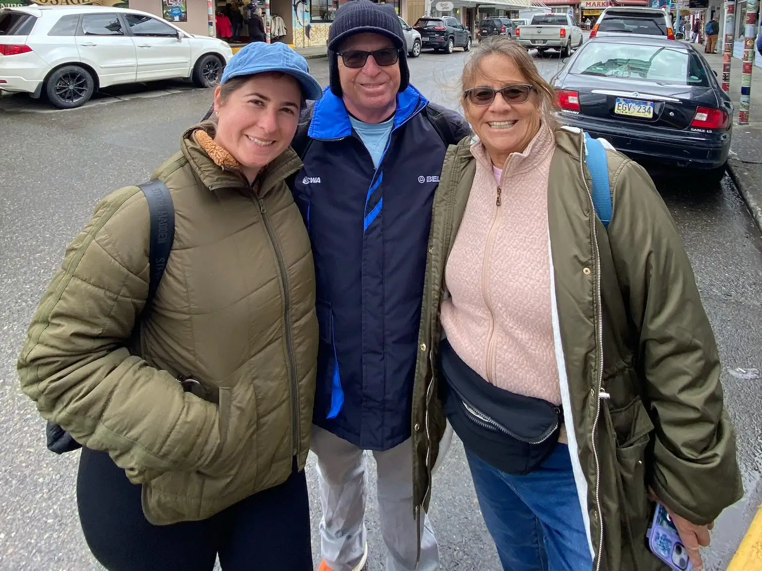 Group of three people in jackets smiling