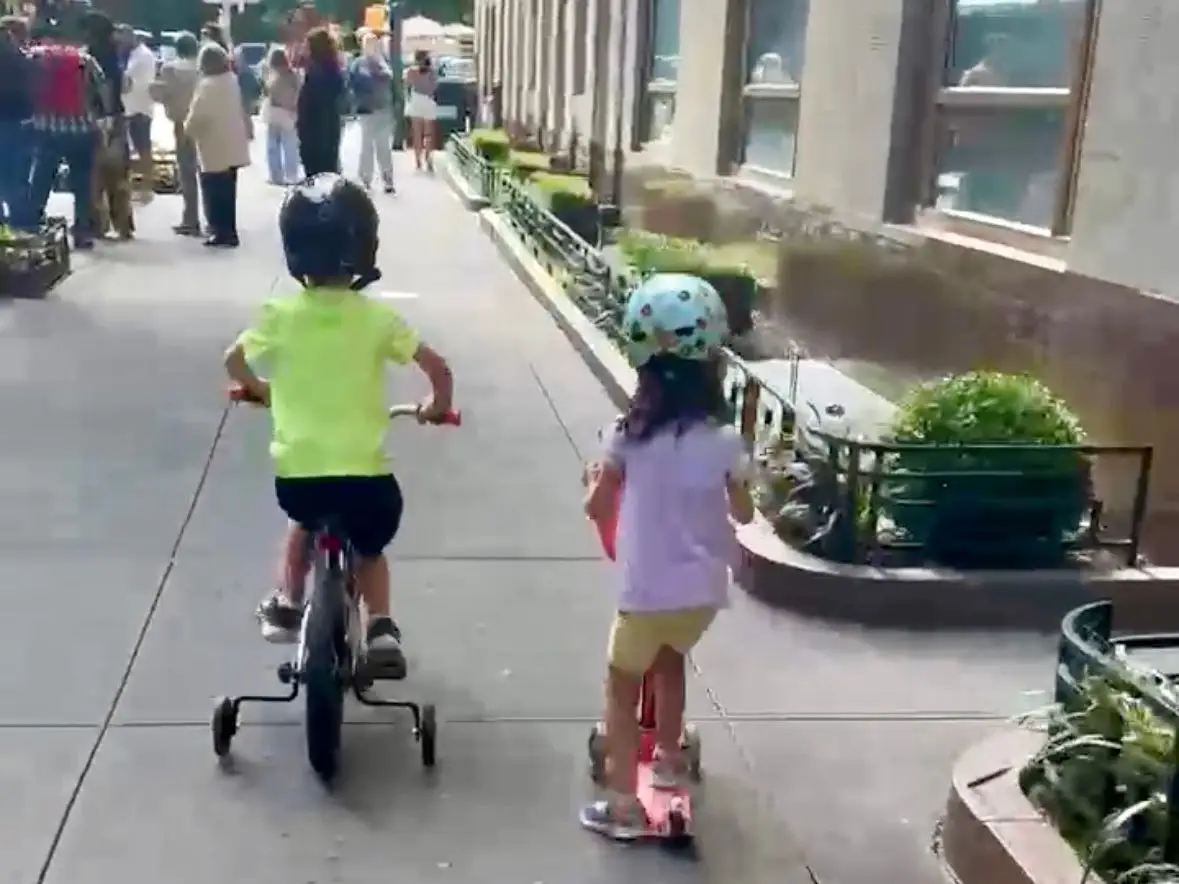 kids biking and scooting on a city street