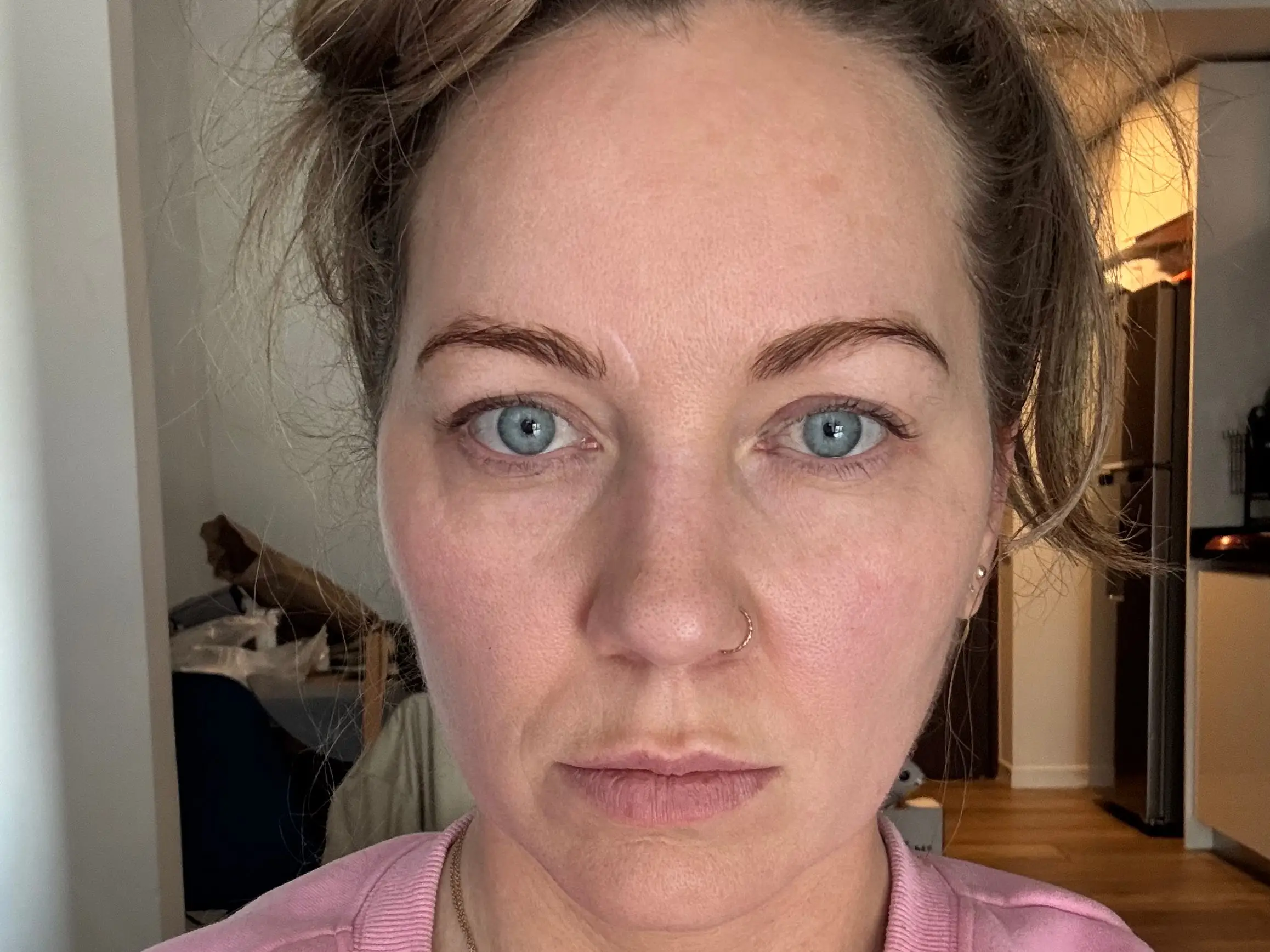 A woman wearing a pink top taking a selfie.