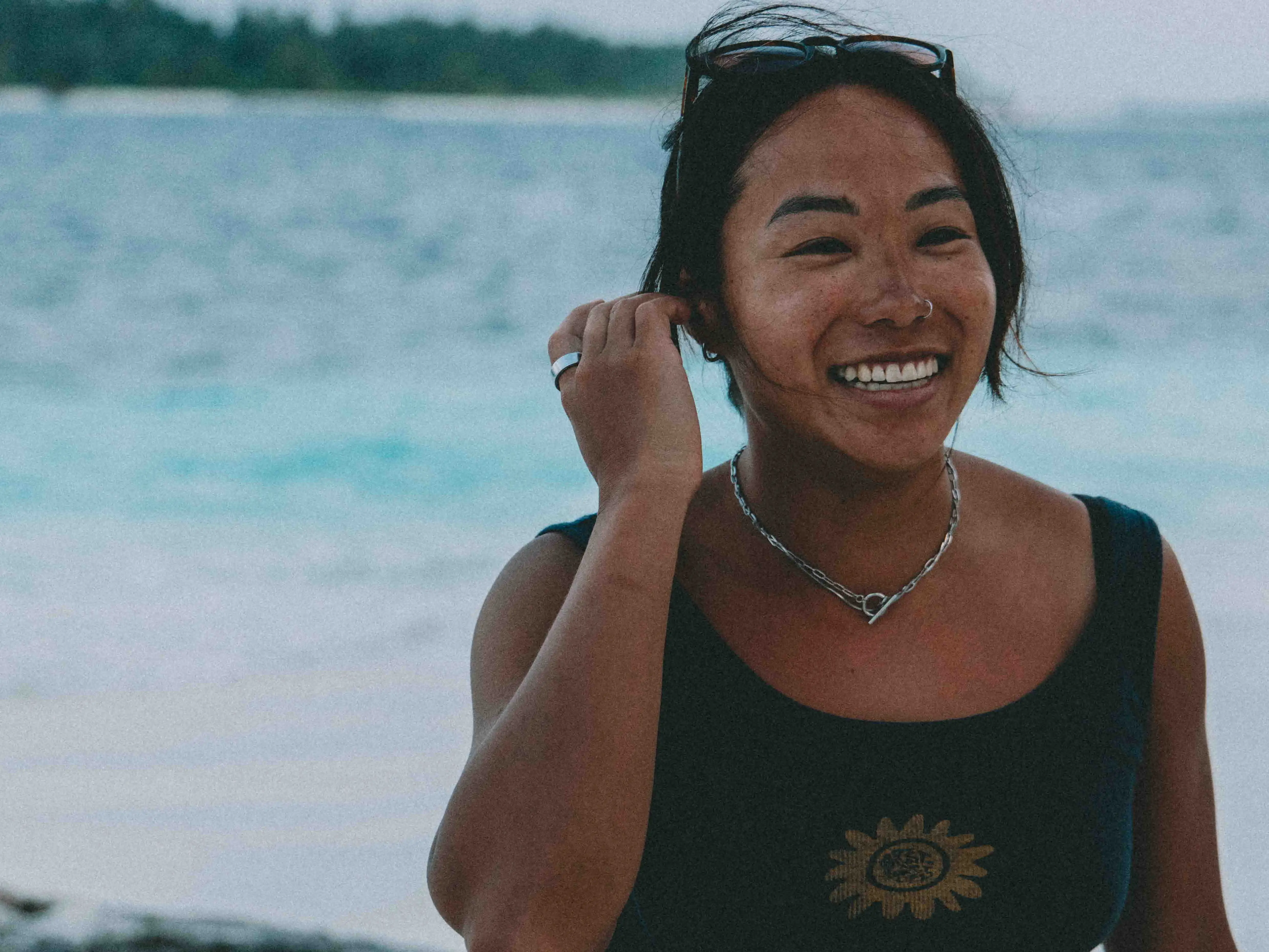 Alice Kim at a breezy beach with the ocean in the background.