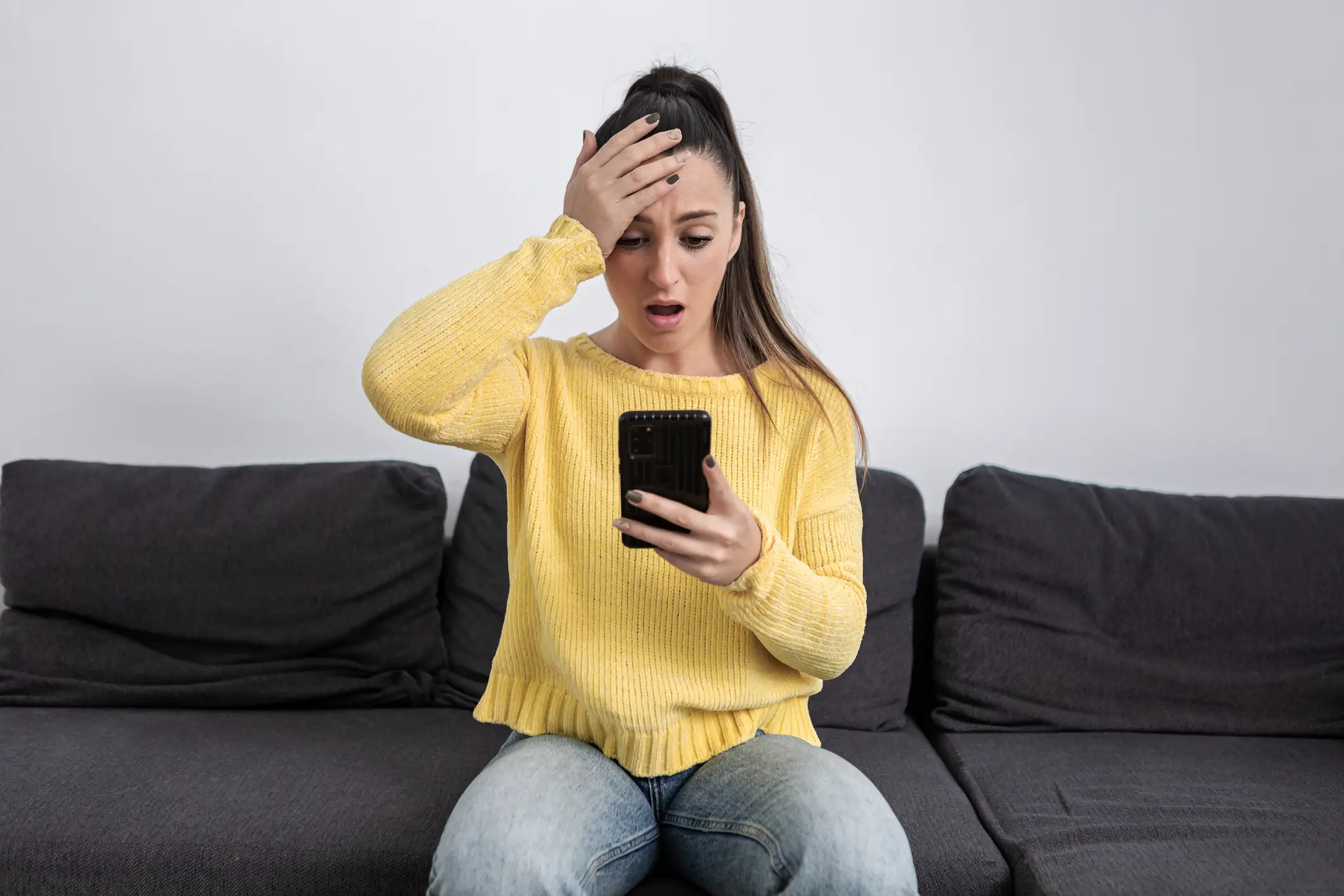 woman in sweater upset at hpone